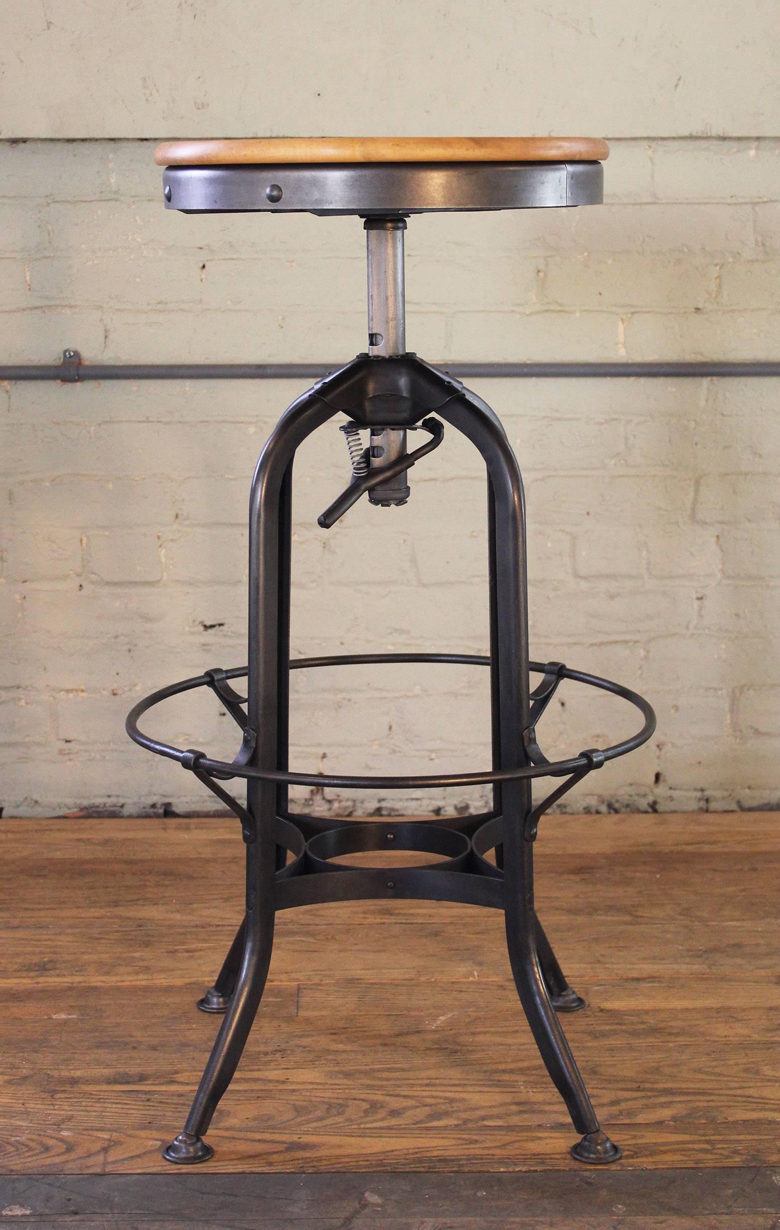 Wood and metal adjustable backless vintage Industrial Toledo bar stool. Seat diameter measures 15 1/4