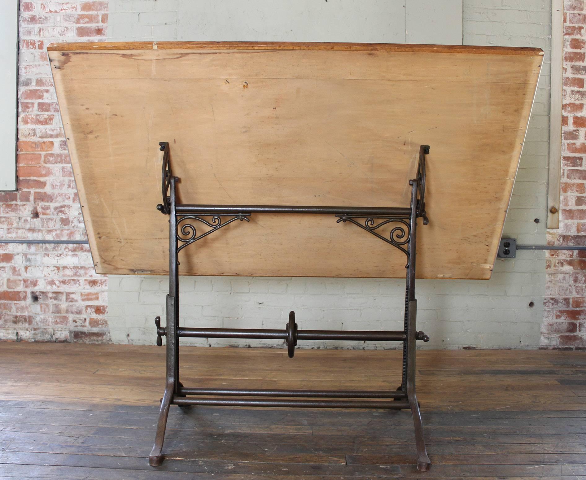 Vintage Industrial antique cast iron and wood ornate adjustable drafting, draftsman, architects table. Top measures 60 1/4" x 37". Top is adjustable from 31 1/4" - 42 1/2" in height.