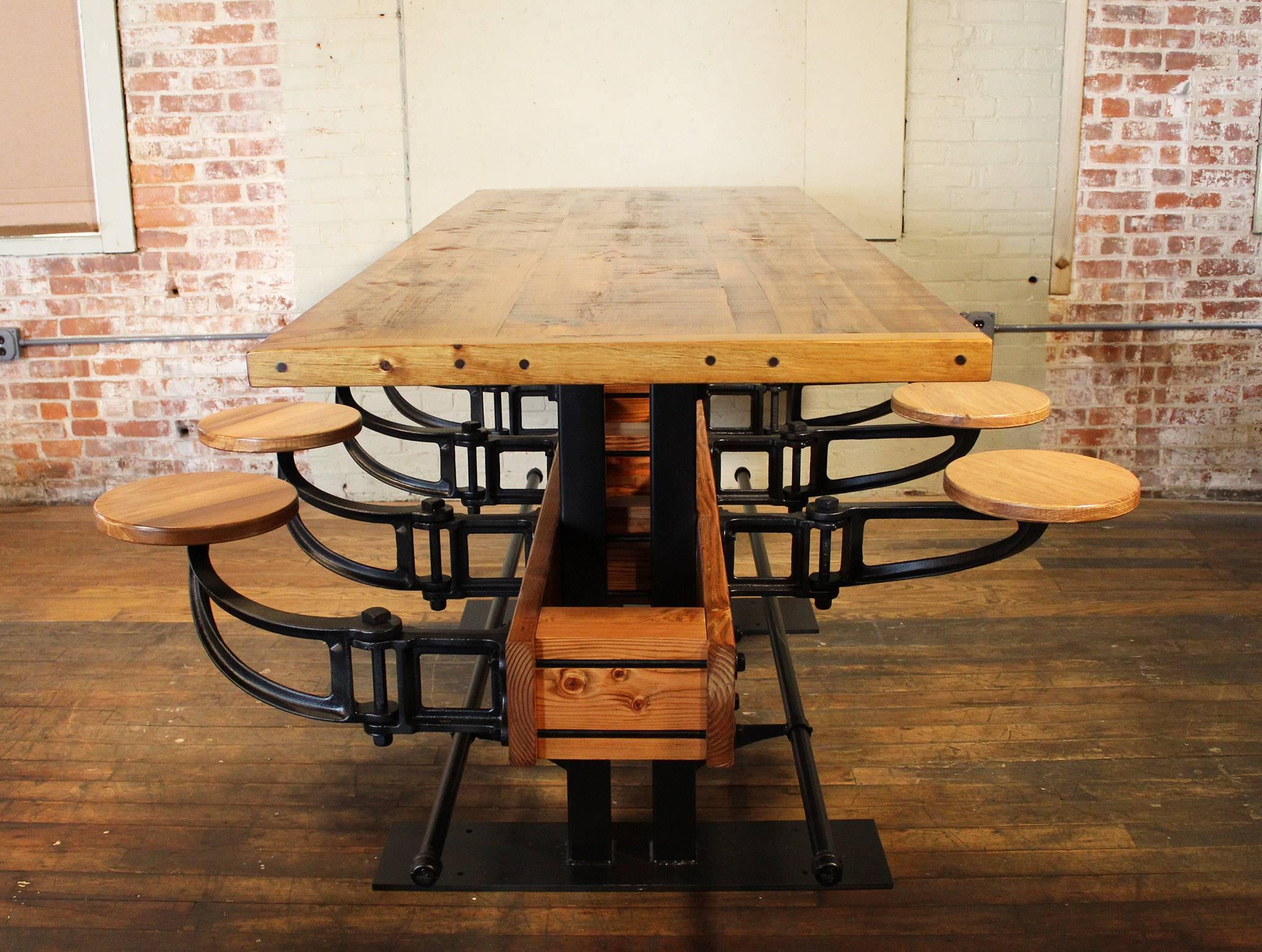 Swing out seat restaurant bar / pub height table. Made from wood, cast iron and steel. Featuring eight cast iron and wood swing out seats, foot rails and 2