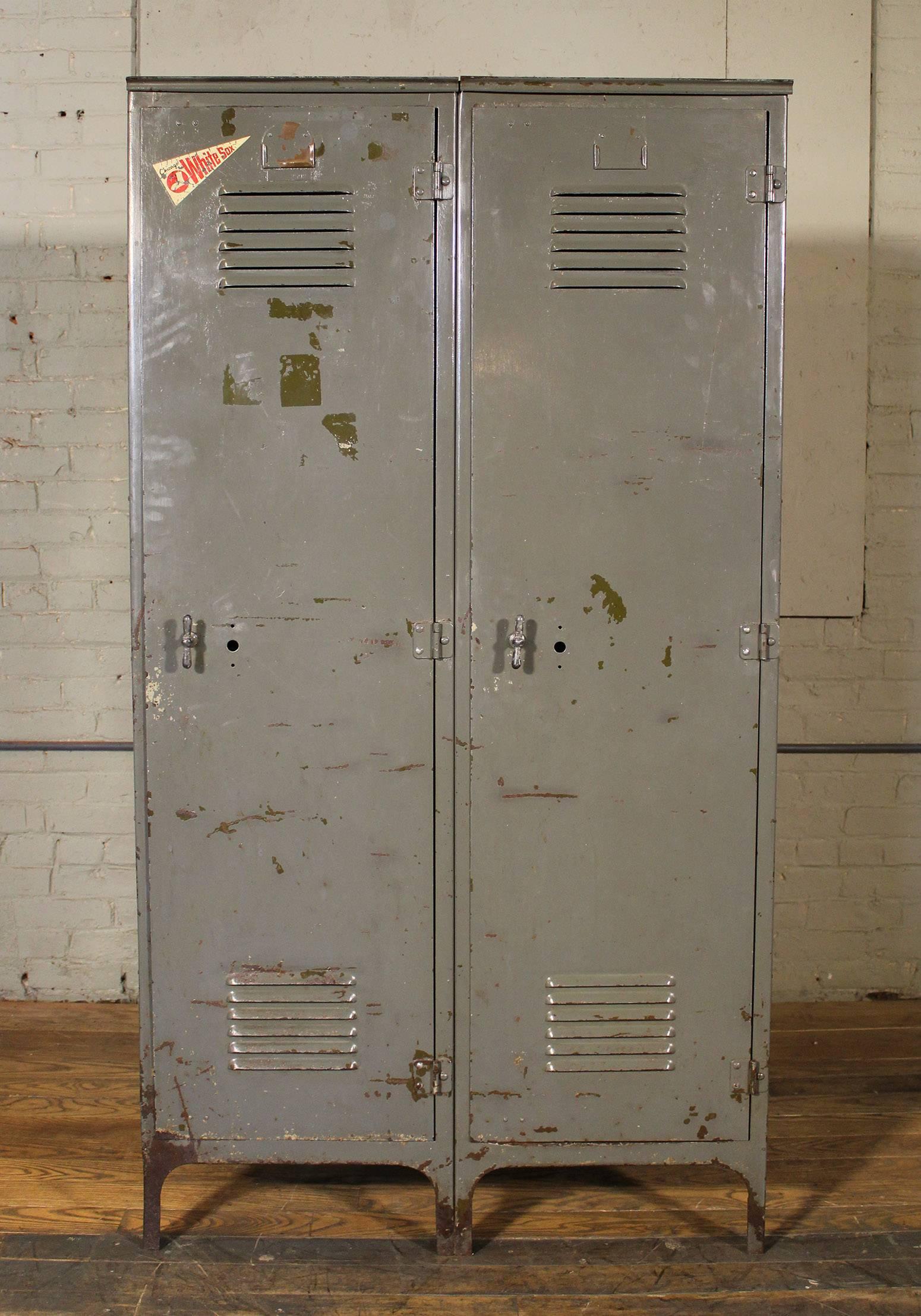 Vintage distressed set of oversized steel metal storage gym lockers. Old Chicago white Sox sticker on left locker. Overall dimensions measure 36 1/2" in width, 19" in depth and 66 3/4". Inside usable space in each locker measures 17