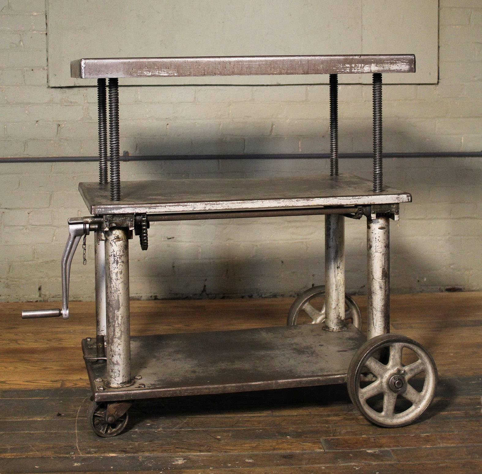 Vintage Industrial adjustable metal, steel rolling three tier lift cart / table with cast iron casters / wheels. Top is adjustable in height from 25 1/2