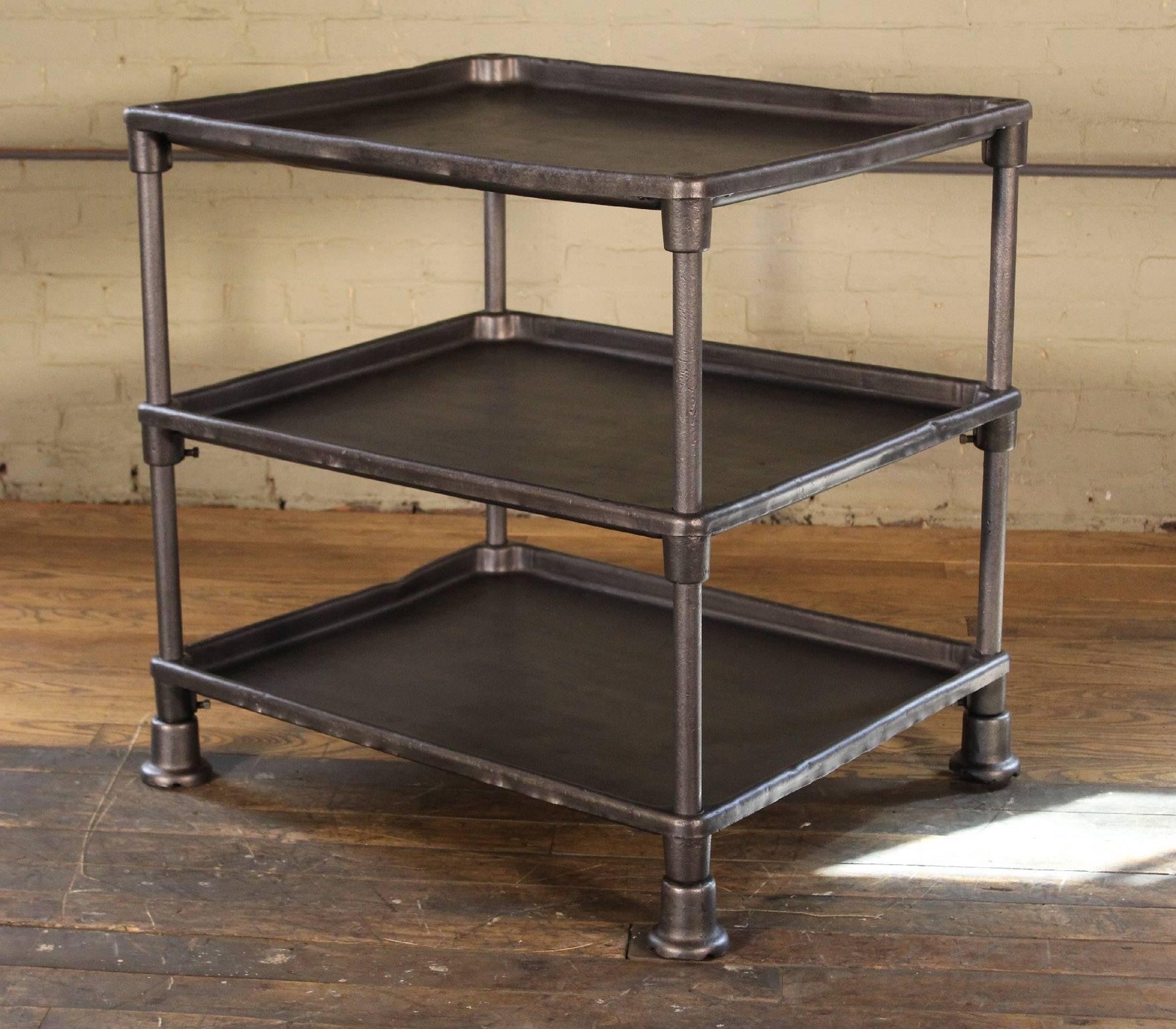 Authentic vintage-Industrial three-tier adjustable factory table. Features cast-iron feet and steel shelves, the bottom two are height-adjustable.