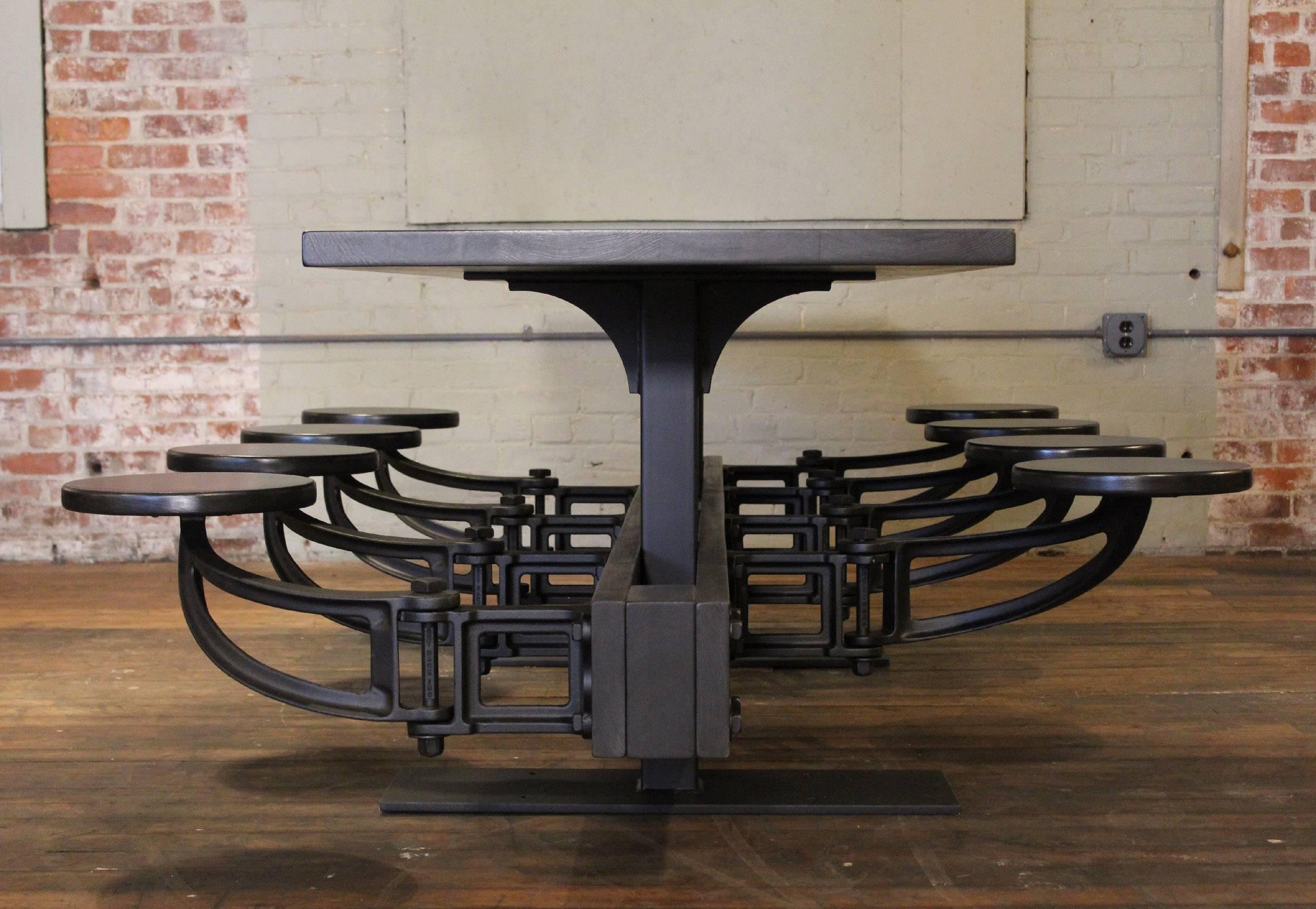 Cast iron and wood industrial swing out seat cafeteria style mid-century modern table. Alder, steel and cast iron. Available in 4-24 seats. Can be linked together. Outdoor version available with Brazilian walnut. 
Quantity and designer discounts