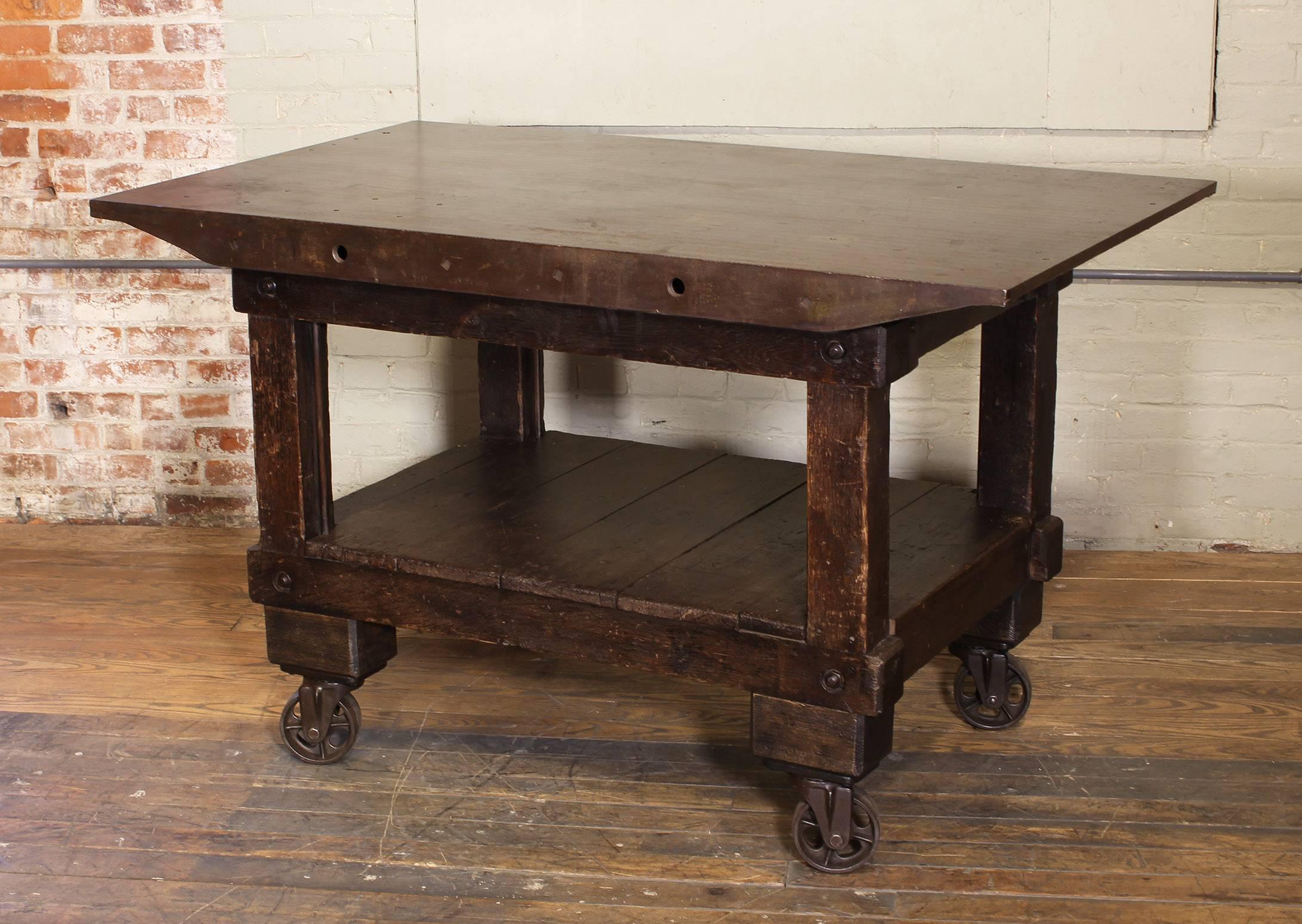 Vintage Industrial rolling kitchen island / table. Made of cast iron, steel and wood, features four swivel cast iron castors. Cast iron top measures 58 3/4