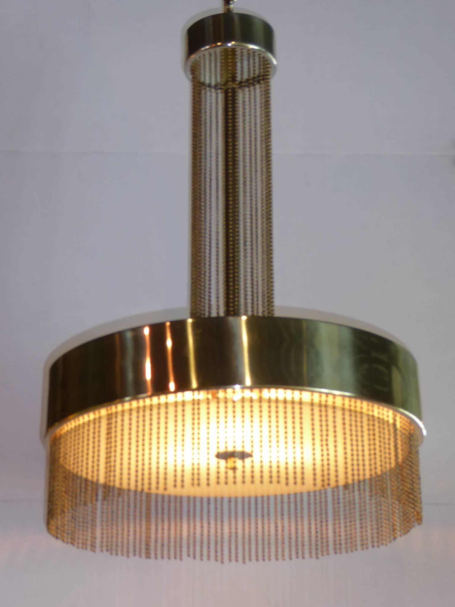 Like a champagne fountain, this Pierre Cardin chandelier is sophisticated and intoxicating with its brass tiers joined by brass bead strands. With three sockets under a center circular glass. Rewired with 36" extra wire to allow for lengthening