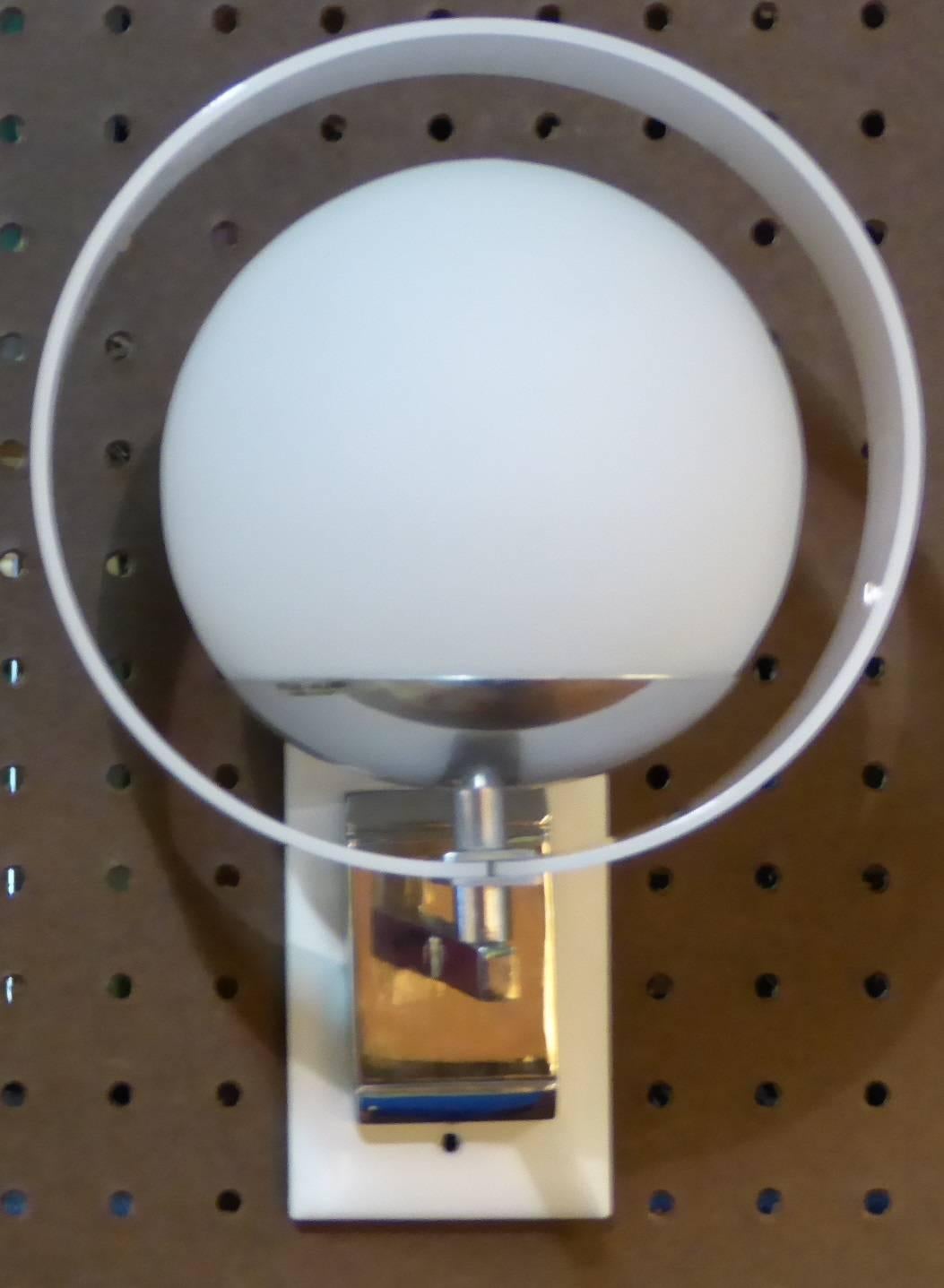 ...ON HOLD....A pair of Italian 1960s Stilux chrome satin globe wall lights with white Lucite rings. Each takes a single medium base bulb, 40 watts max suggested. Space Age Saturn Ringed Sconces. Both with Stilux Milano decal labels.
Measurements: