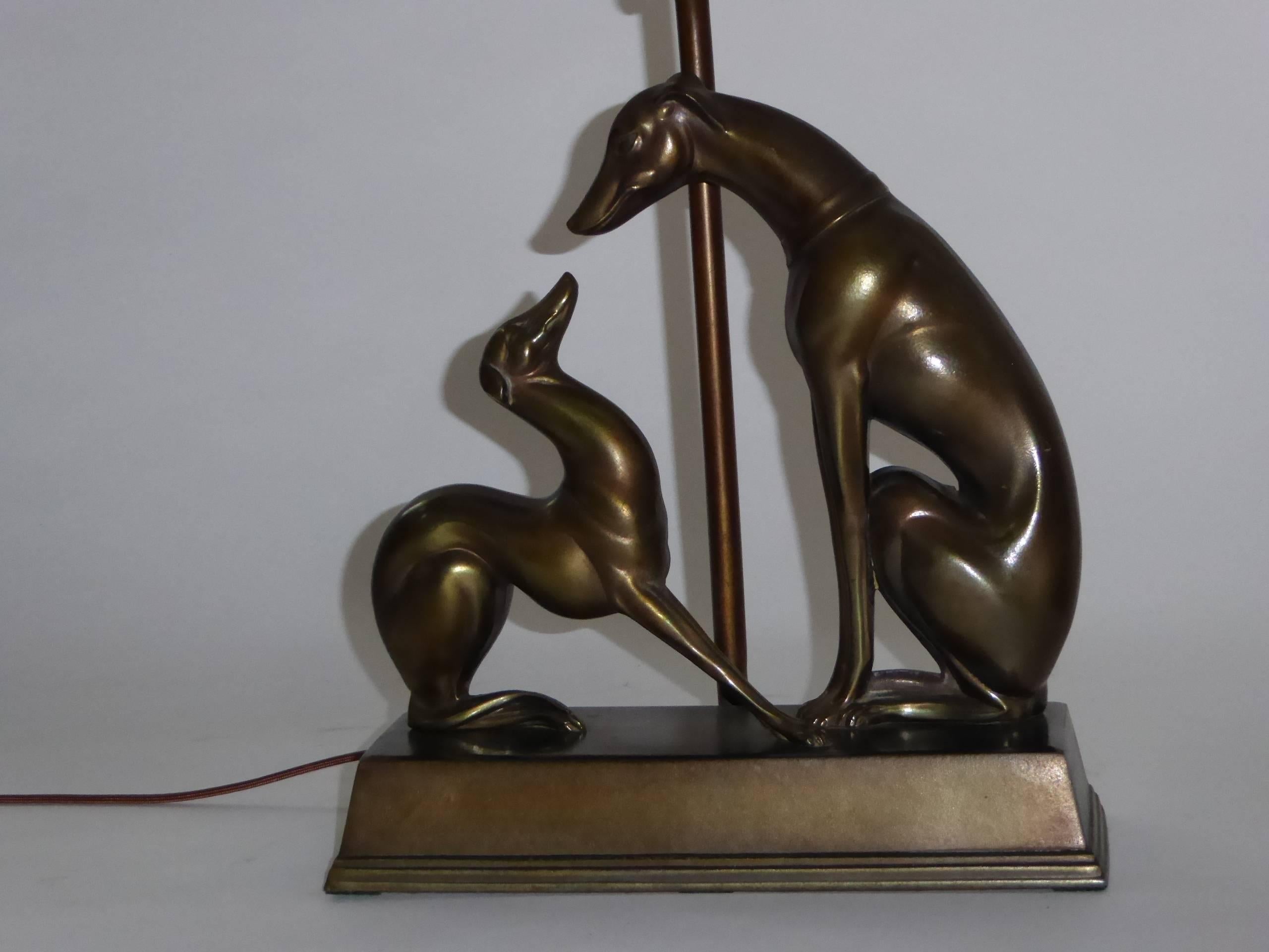 Whether they are Whippets or Greyhounds, these bronzed figural table lamps featuring a mother or father dog with a young pup seated on a rectangular stepped base are stunning. Stamped on the bottom May 8, 1933. All original including the finial,