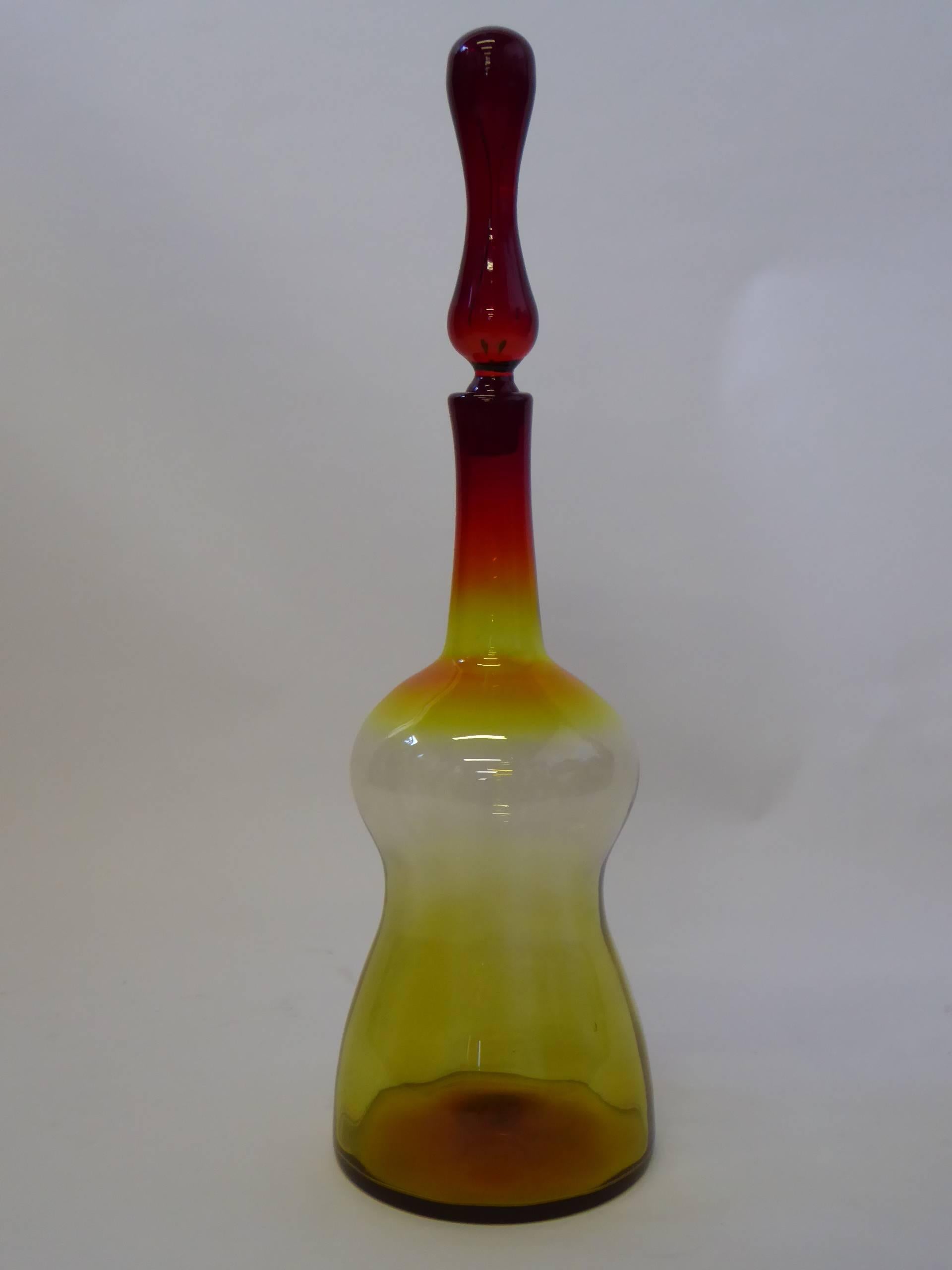 Wonderful and large Mid-Century blown glass floor decanter by Joel Myers for Blenko. In mixed color Amberina. Dating from 1969. Exceptional tall stopper.

Measurements: 27 1/2