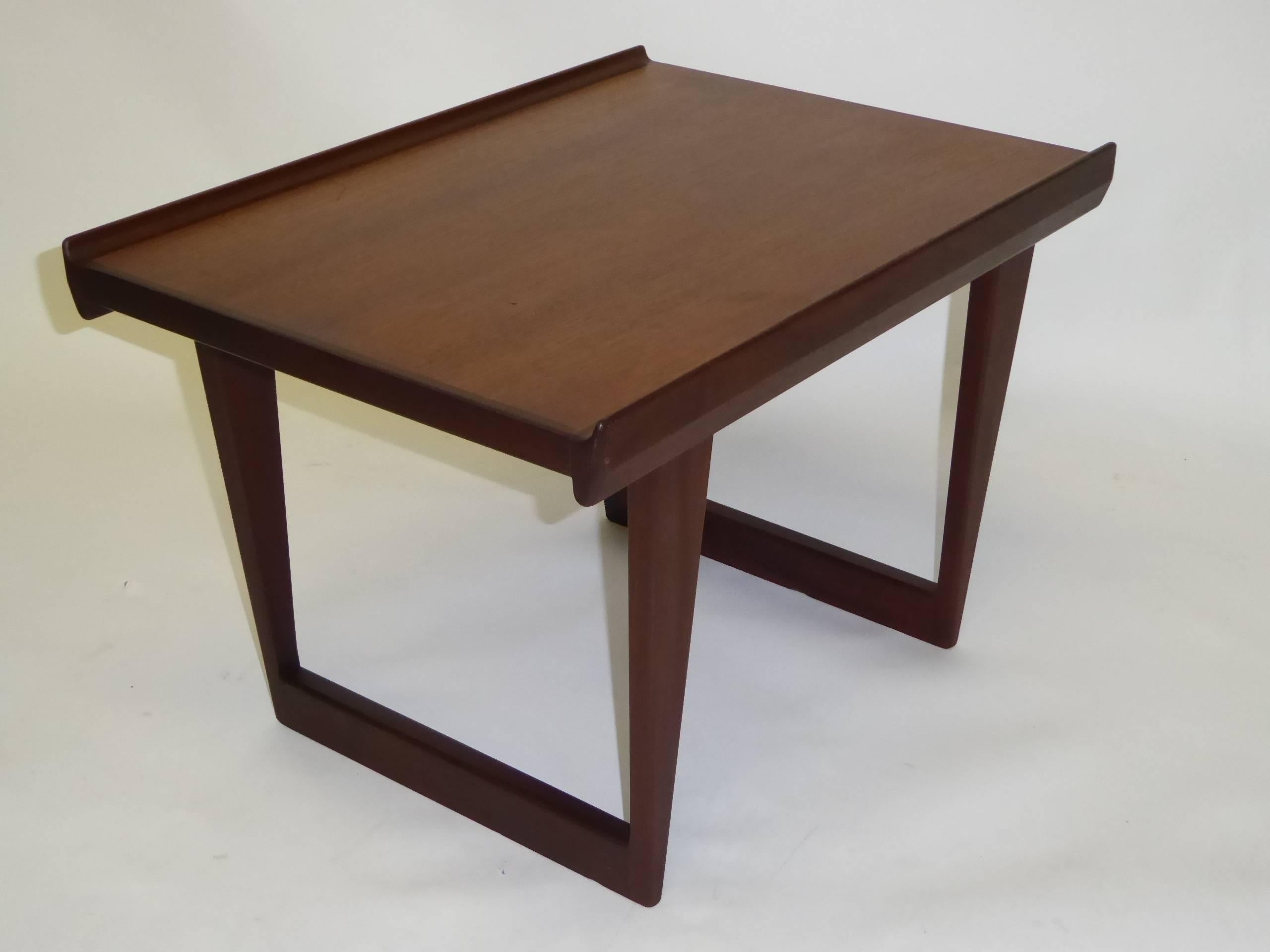 This teak side table or coffee table was designed by Peter Løvig Nielsen and manufactured by Løvig in the 1960s in Denmark. It is made with two tones of teak. Branded on the underside Lovig Dansk Design and stamped twice 1963. This piece is in a