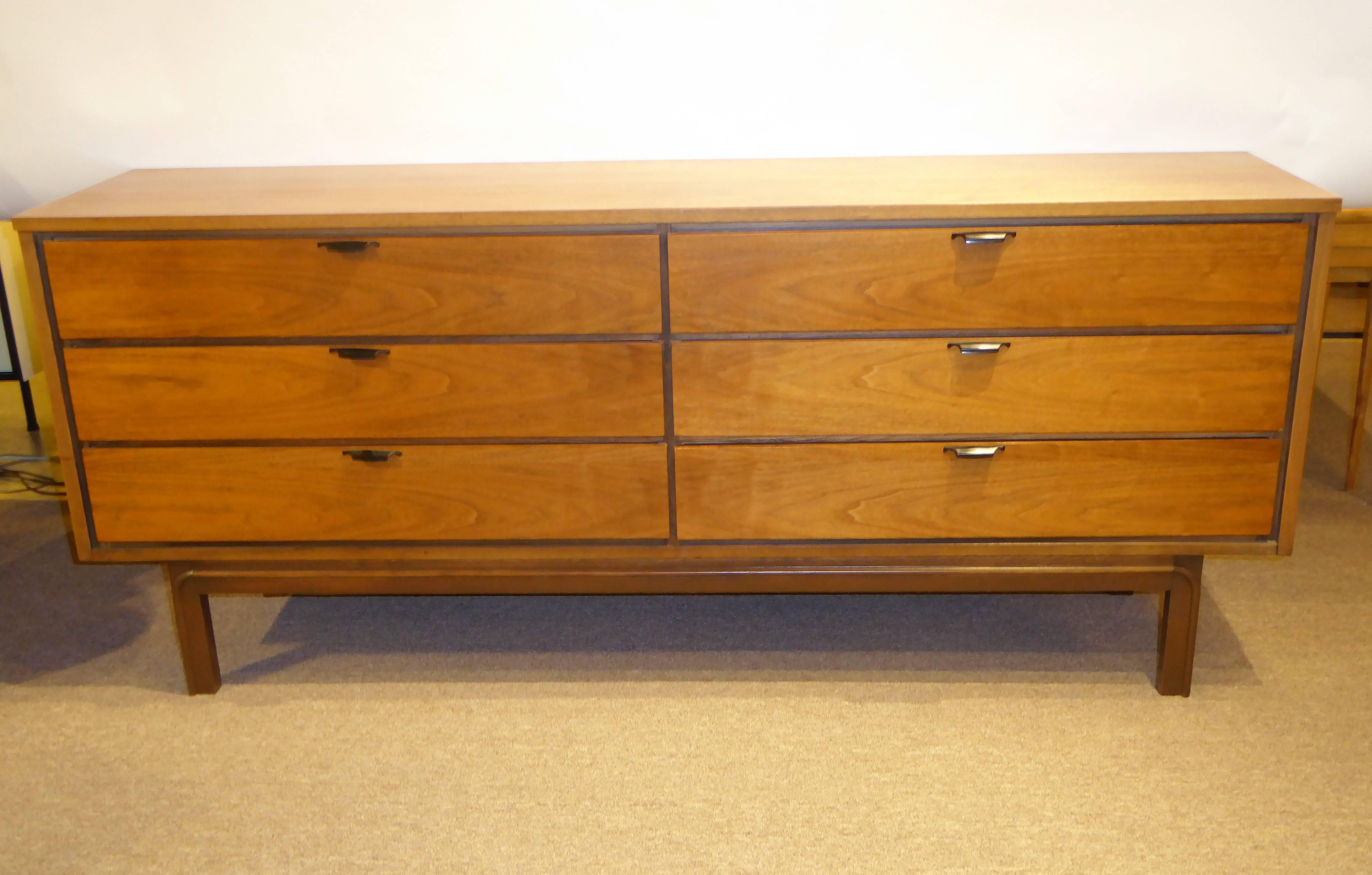 REDUCED FROM $2150....Sleek and modern with minimal accents and crisp, clean lines, this late 1950s walnut six-drawer dresser or credenza has very figured walnut with ebonized drawer surrounds and black drawer pulls. In very nice original condition.