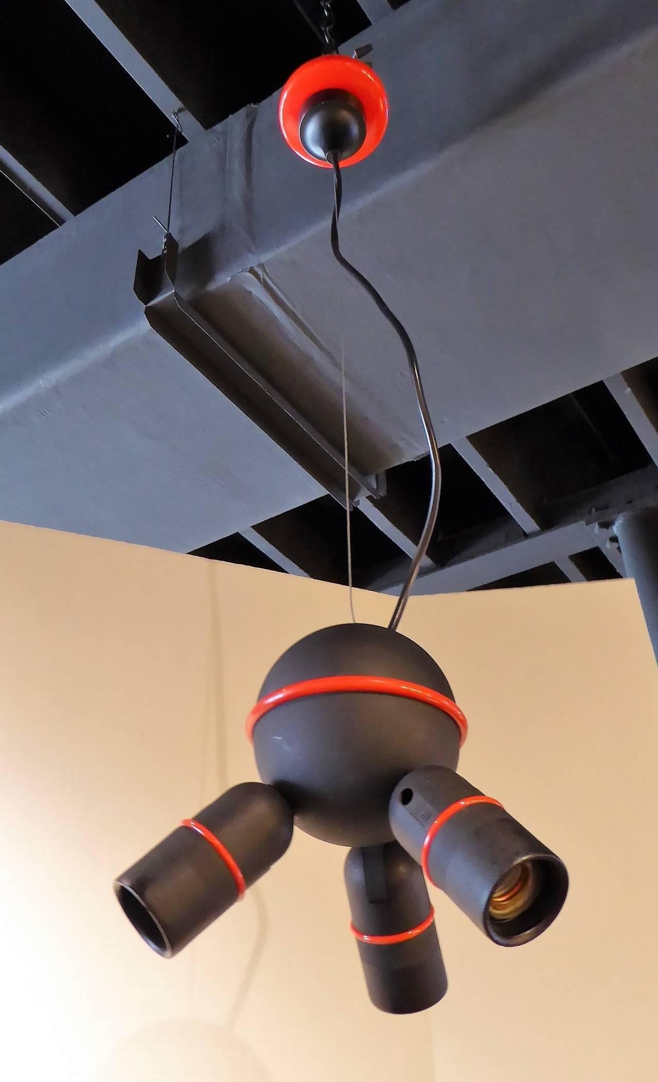 Roger Tallon (1929-2011), world re-known French Industrial designer. A black with red accents three light fixture, edited in France by Lifa. The arms are fully adjustable in direction. Side to side, up, down. Takes three standard Edison base