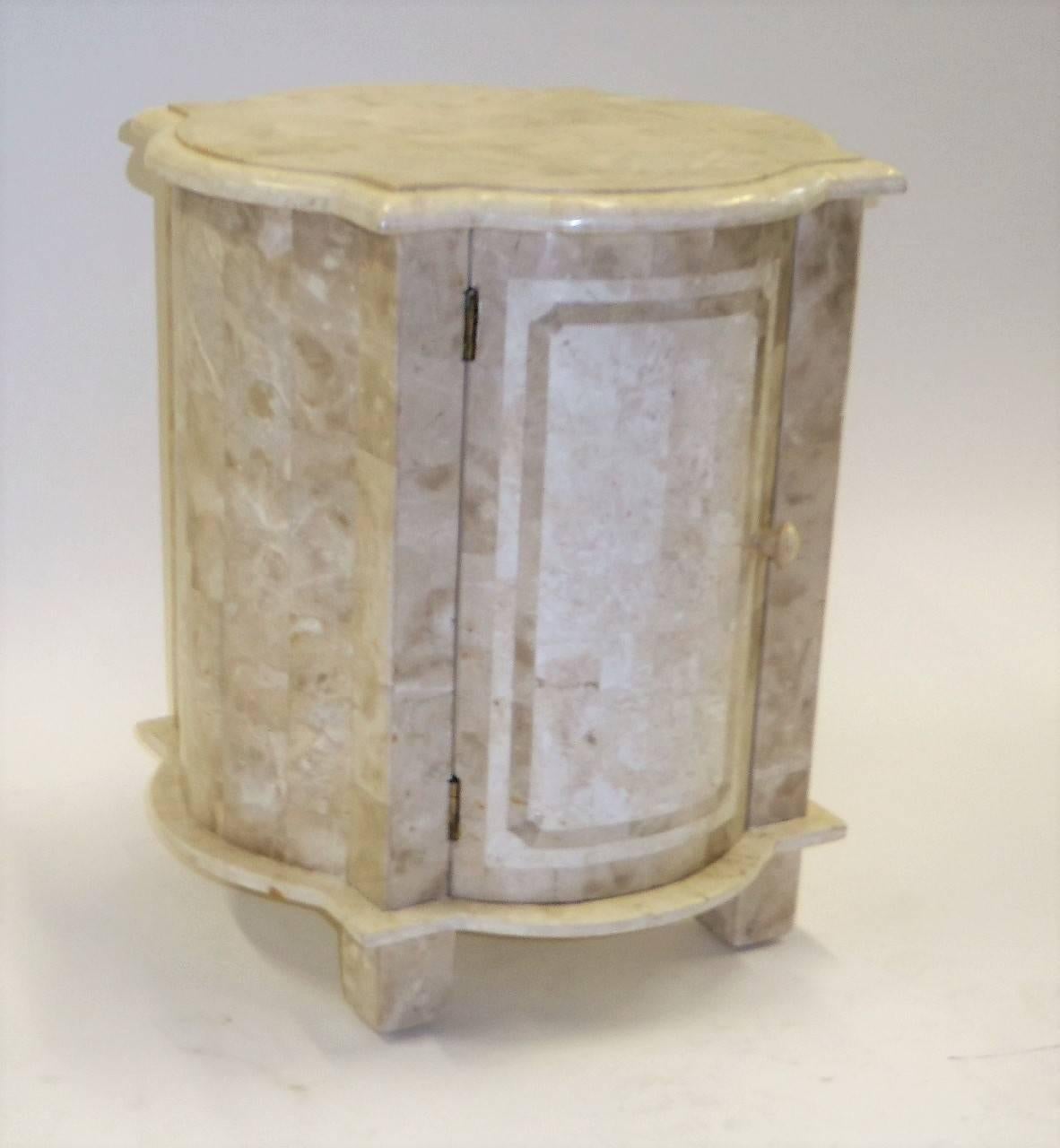 With a Moorish shape from the past, yet quite modern, this exquisite bedside table or side table is composed of tesselated inlaid fossil stone buffed to a elegant shine. With a single door opening to storage. From the Marquis Collection of Beverly