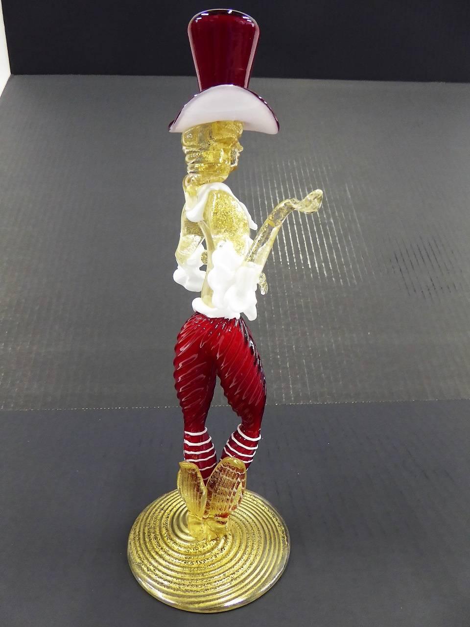 REDUCED FROM $475...Modern striking Venetian blown glass figurine of a male courtesan with exciting top hat. With Venetian 18th century dress frills, done in cased glass, deep red and clear with gold leaf inclusions and applied white glass. Long