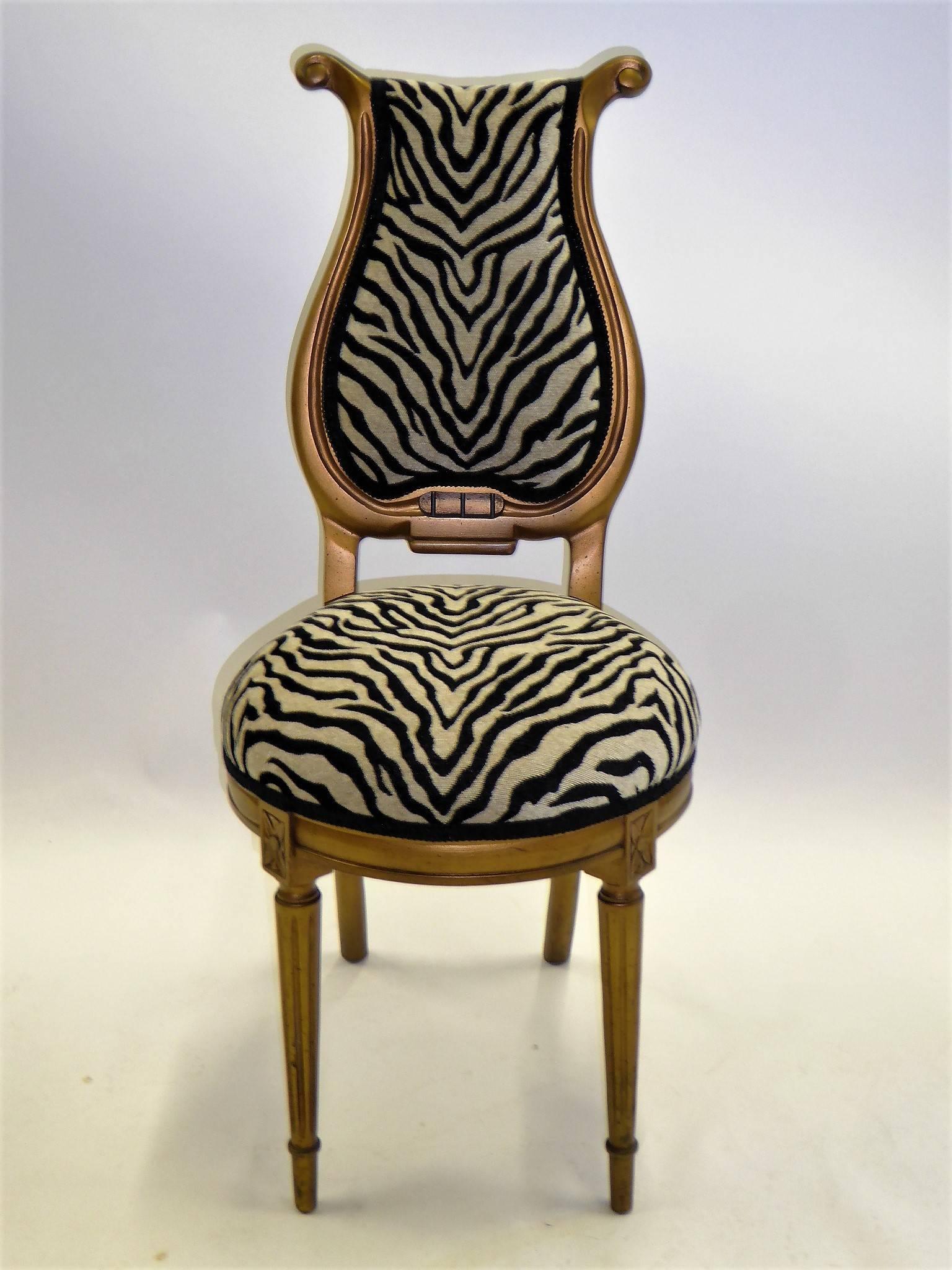 1940s stylized musical motif side chair upholstered in luxe chenille zebra fabric. With a streamline modern lyre shaped back and Louis XVI style front legs, it has soft gilt gold finish.


Measurements: 39 inches high back x 17 inches wide x 23