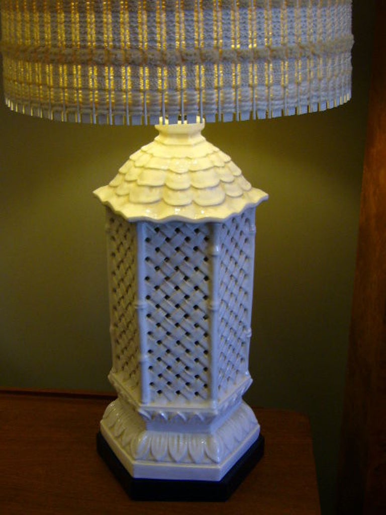 REDUCED FROM $675....Fine Japanese Lantern themed lamp. White glazed reticulated ceramic base is of a stylized Japanese lantern with tiled roof, six sided imperial trellis lattice walled sides and lotus blossom base over a black wood plinth base.