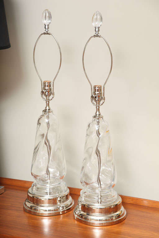REDUCED FROM $1,600....Thick swirling clear crystal in a baluster form highlights this pair of Orrefors blown table lamps with stepped socle form silver nickel bases. Beautifully topped with finials of blown crystal. All hardware renickeled, lamps