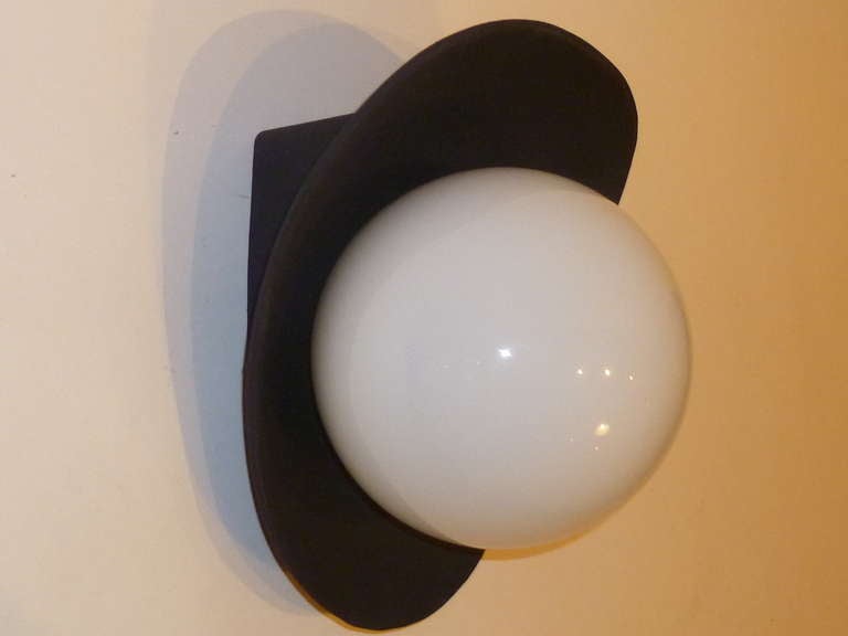 This pair of round globe wall lights or sconces are quite smart with their scalloped black iron collars and white glass globes. Modern with a bit of pop, they each take a single medium base bulb, 60 watts max. New, old stock, never used.
Price is