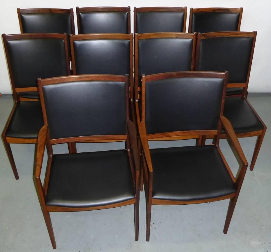 Fine, elegant and regal in Brazilian rosewood, these ten dining chairs, including two armchairs exhibit the design detail of Ib Kofod-Larsen. Beautiful figured Brazilian rosewood of the period, original black leatherette in very good condition with