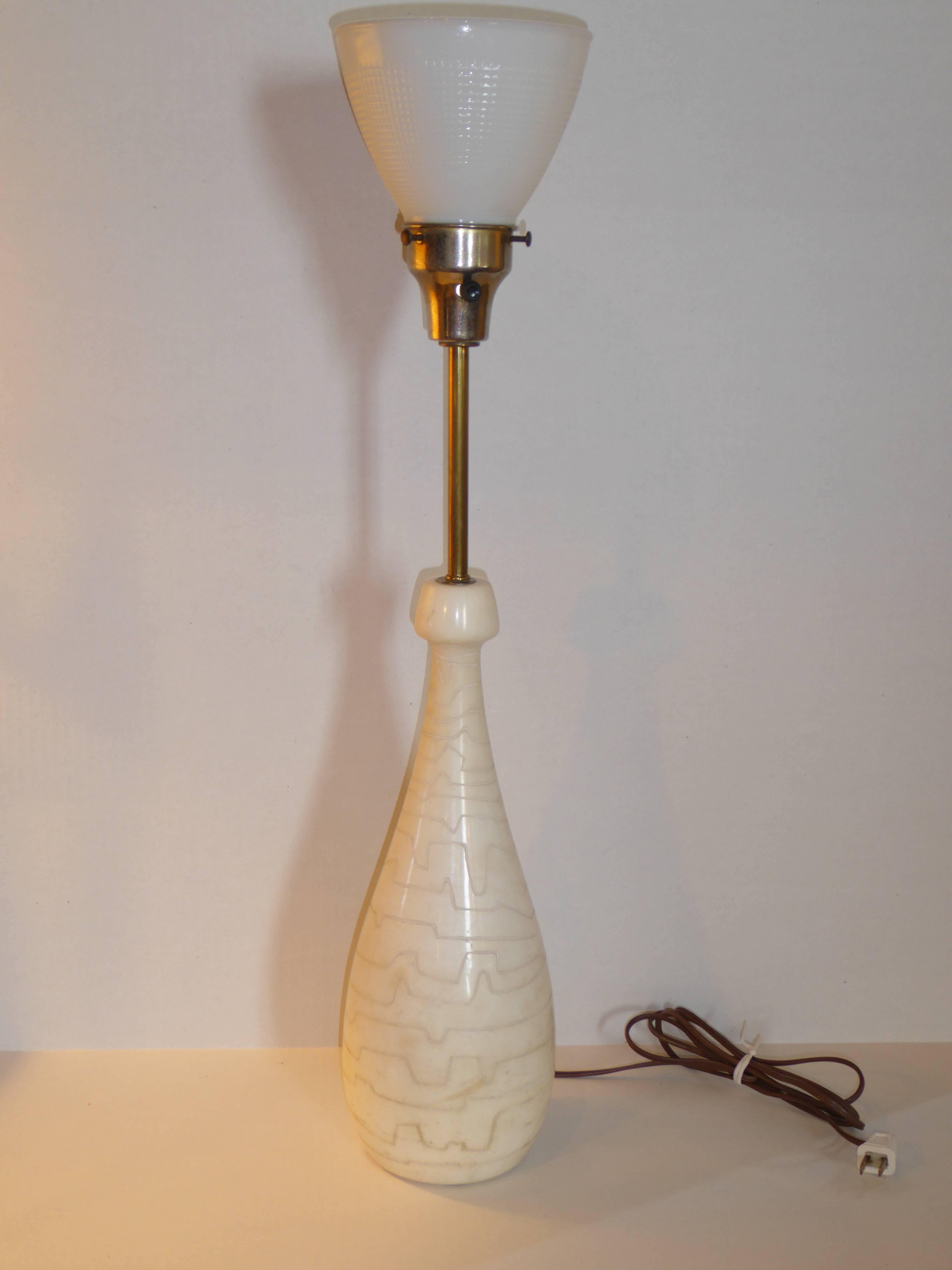 Beautifully formed teardrop bottle shaped marble table lamp with etched squiggly lines around the body. With a brass stem rising to a milk glass diffuser. Solid marble. Just add your shade. Shade shown as example.
Raymor label inside socket