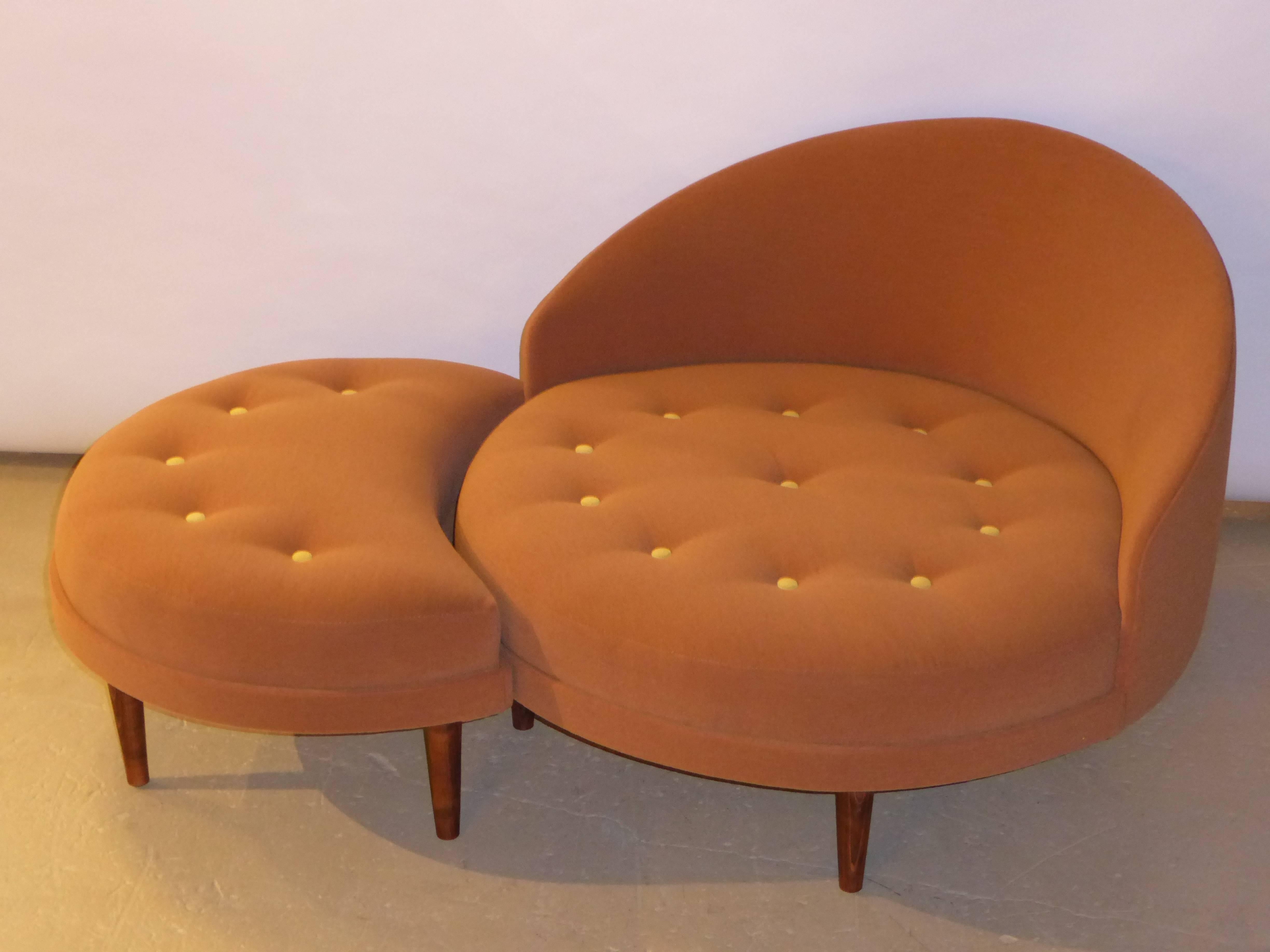 Wonderful tony design by Adrian Pearsall for his firm Craft Associates, this button tufted lounge chair with fitted ottoman has a comfortable low scale, sporting fat tapered walnut legs. The fitted 3/4 moon shaped ottoman with the same walnut legs.