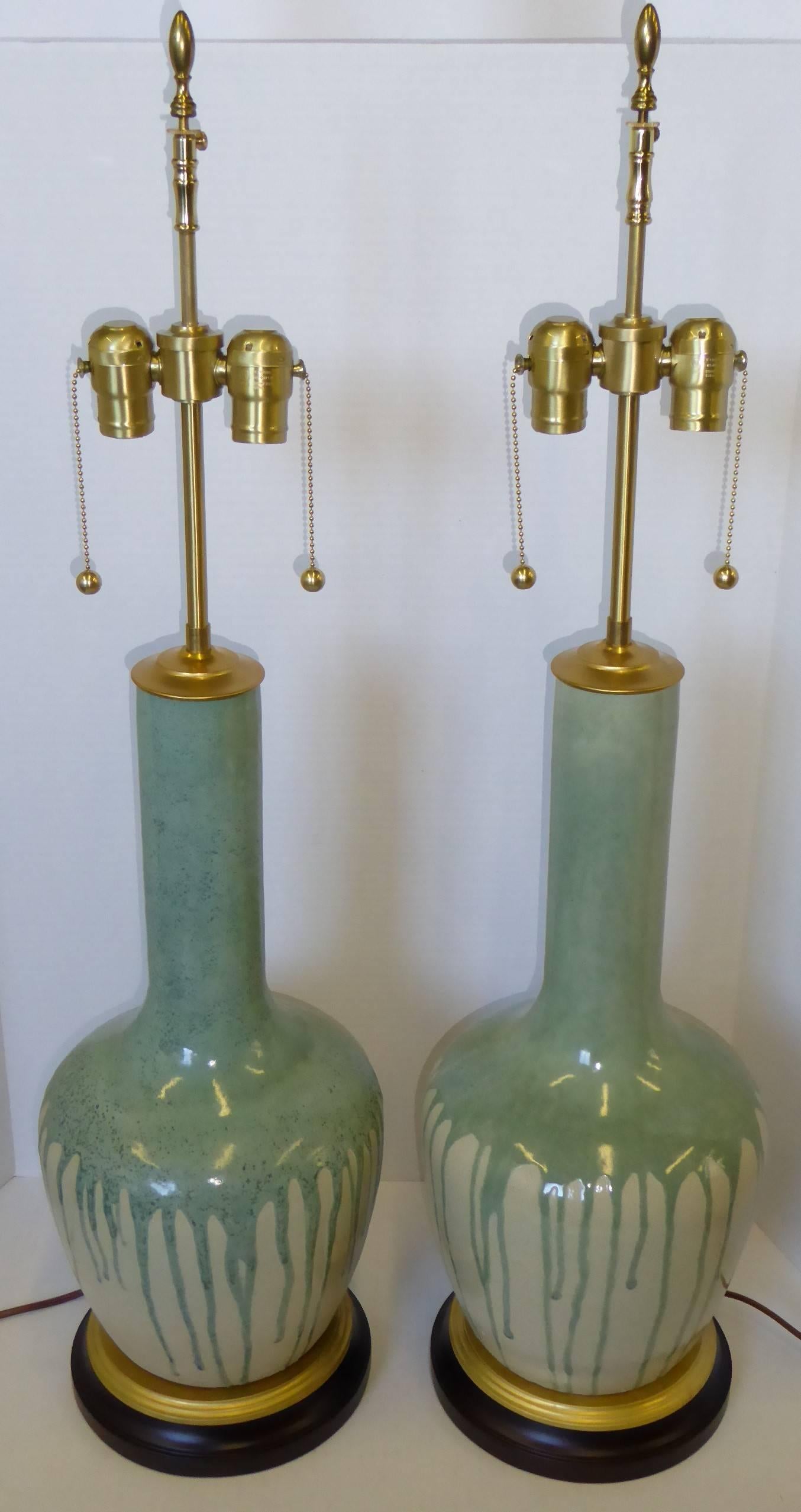 
Exciting pair of tall neck bottle form vases with drip glaze, as lamps on dark mahogany and brass bases rising to double socket clusters. Rewired with new UL sockets and silk wrap cord, in excellent condition. Just add your shades. 
Designed by