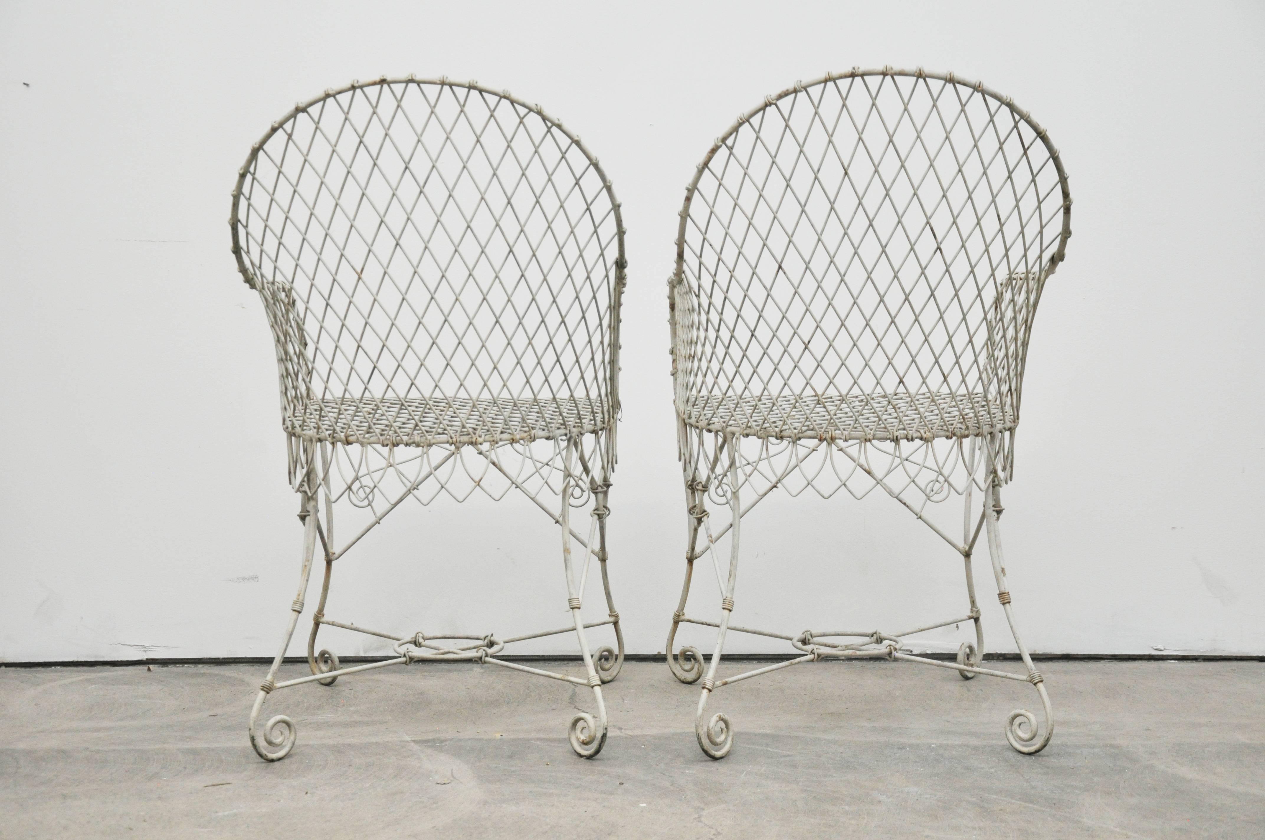 A pair of vintage 1920s French wire garden chairs. Wire painted white.

Measure: 17.5 seat height.