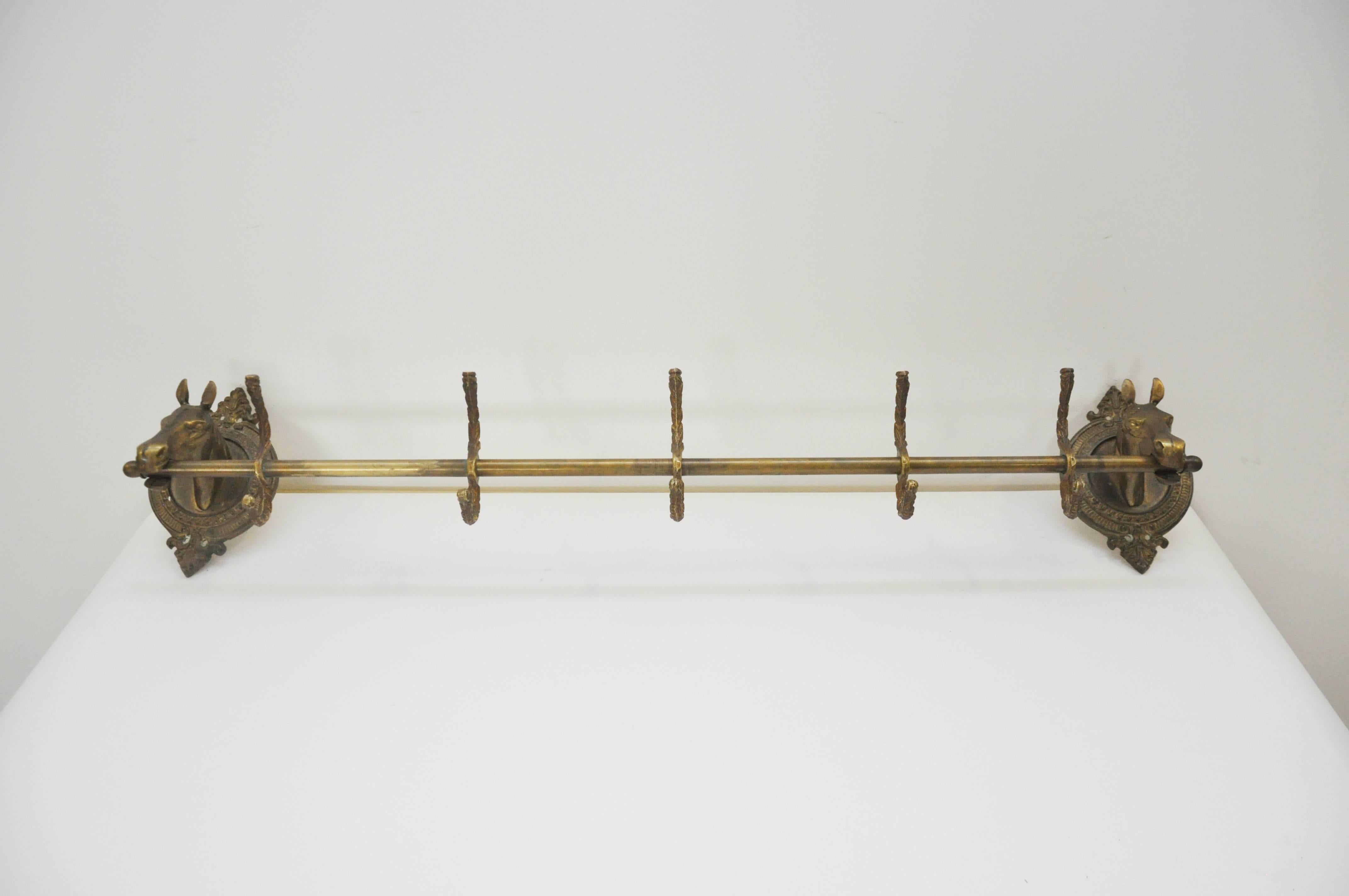 Detailed brass wall-mounted hooks with horse heads. The rod is in the horses mouth and holds three brass hooks. This piece does not come with screws to attach the piece to the wall.