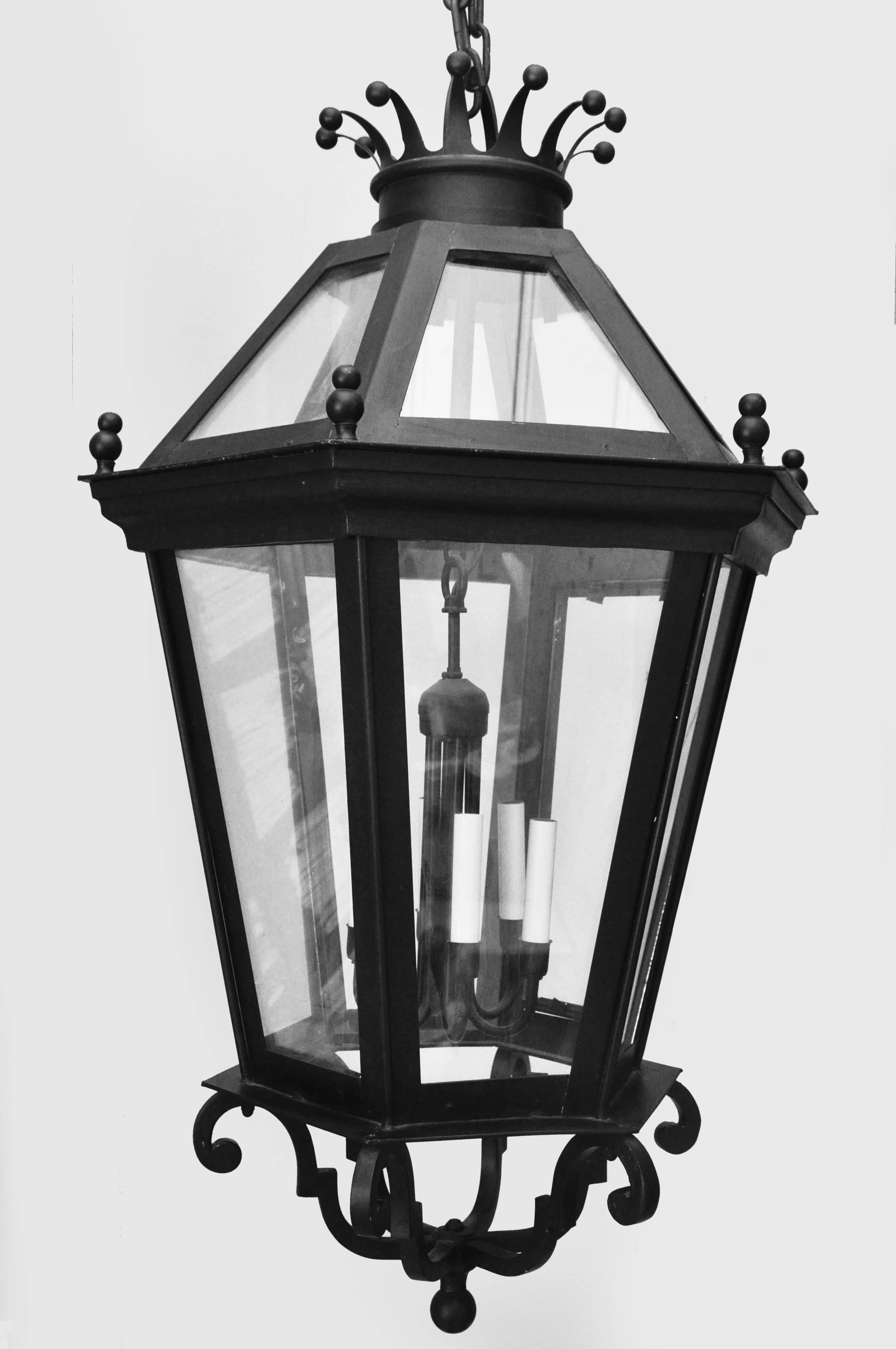 Vintage 1990 large scale black iron hanging lantern. The lantern has four candelabra based light sockets for bulbs up to 60 watts each. The lantern has never been used and from a high end lighting source. Crown top design, single door opens in order