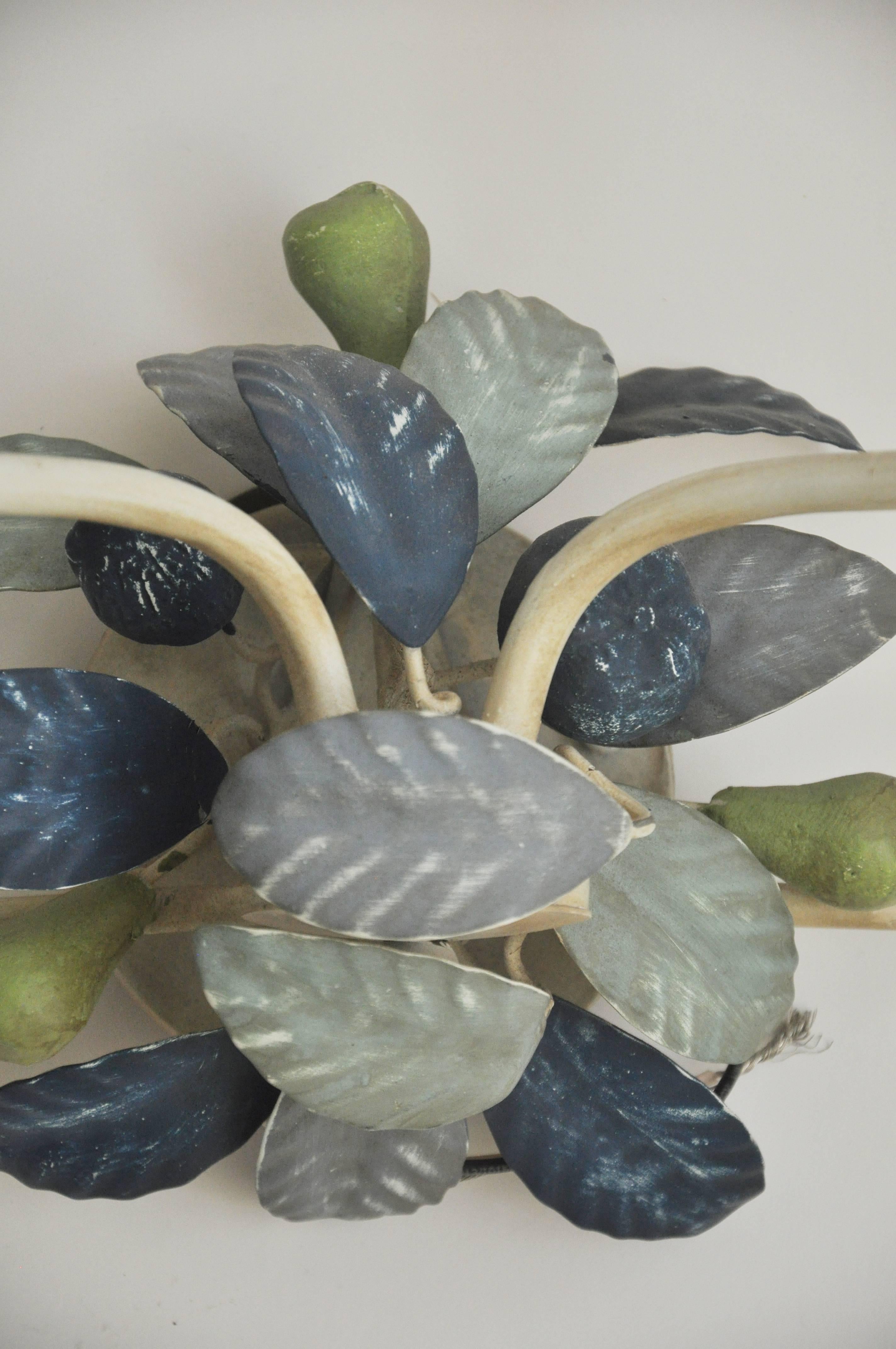Unusual and beautiful pair of Italian tole sconces from the1960s. Hand-painted in shades of blues and greens. The sconce resembles a bird perch with leaves and fruit. Each sconce has two light that take a candelabra style based bulb up to 60 watts