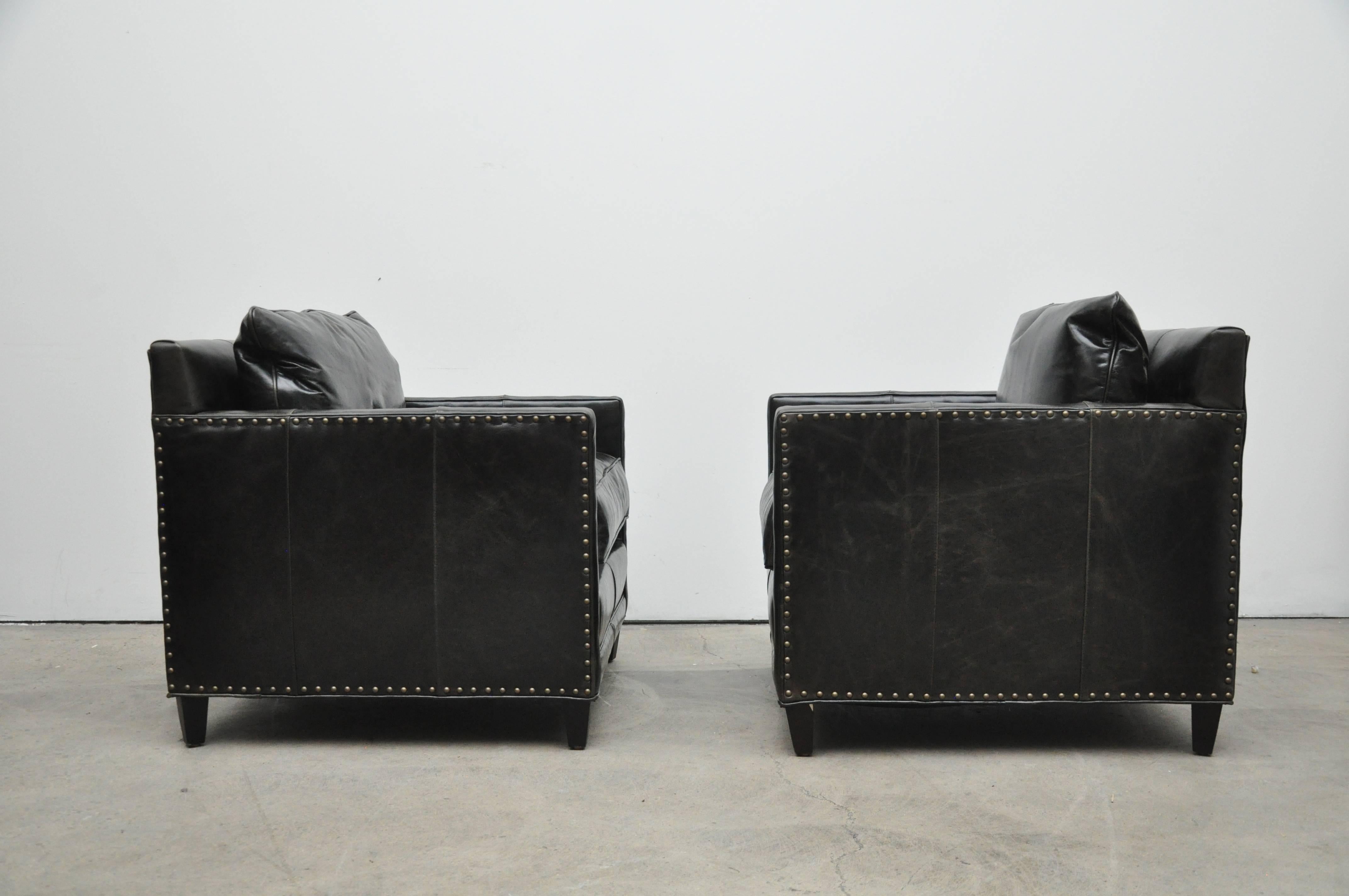 Pair of new black leather club chairs.