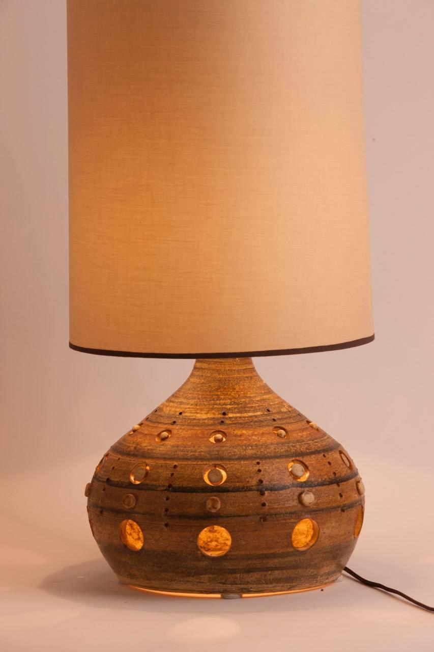 French ceramic table lamp by Vallauris artist Georges Pelletier. This lamp can be illuminated three ways.  By the bulb in the socket within the shade, or the bulb that is suspended within the body of the lamp, or by both. The custom shade was made