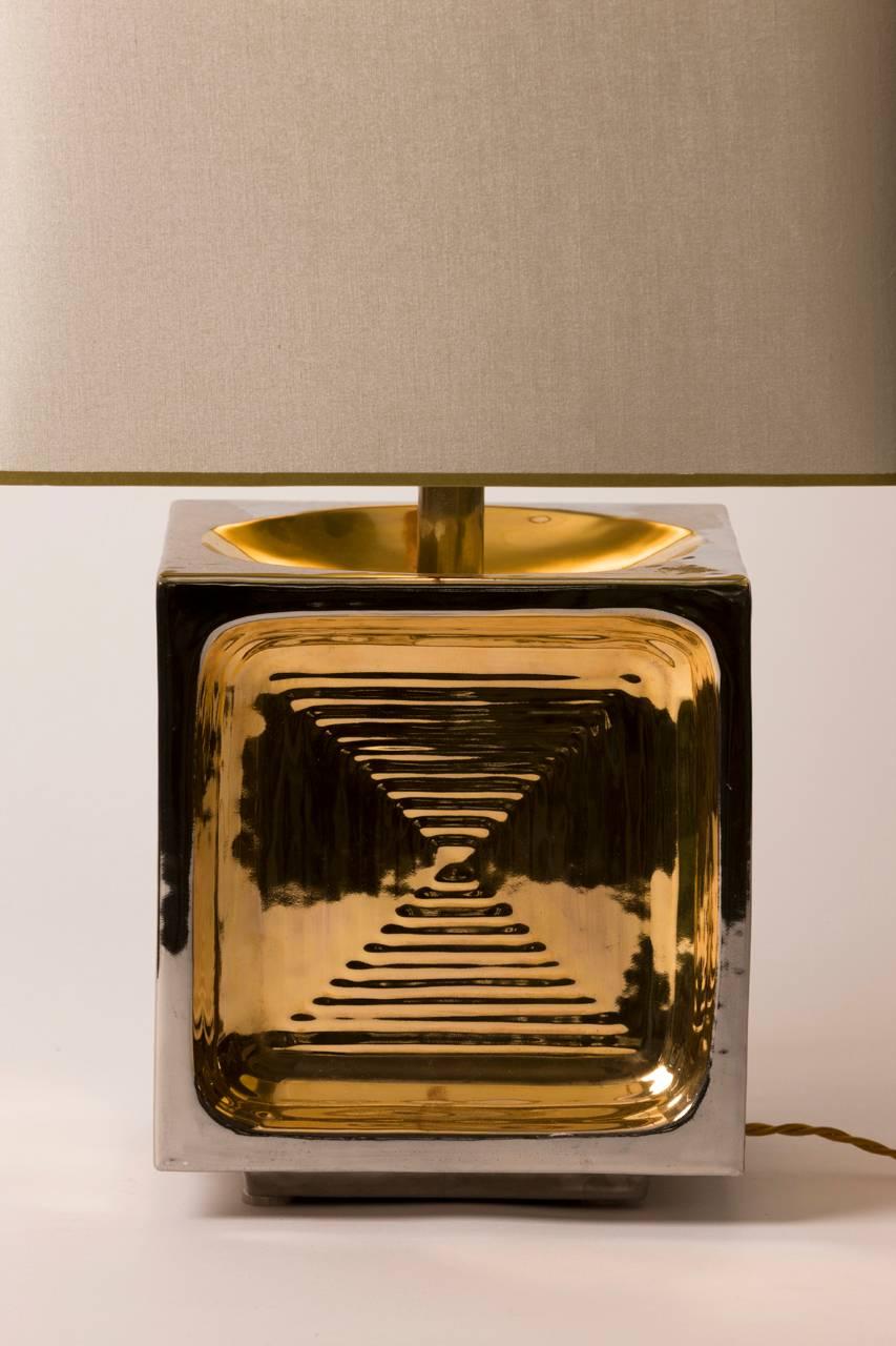 Mid-Century Modern French ceramic table lamp featuring gold and silver glaze over a ripple motif. Custom gilt lined silk shade created in Paris.
