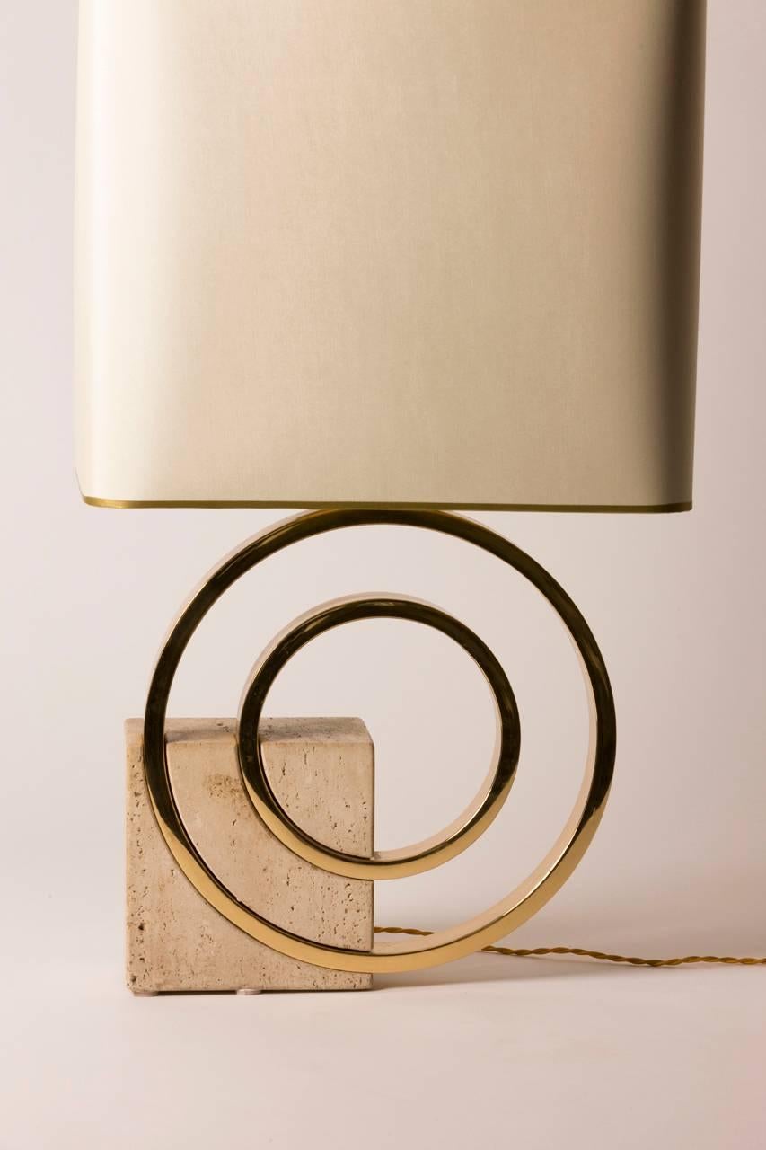 Mid-Century French table lamp featuring a brass circular body anchored by a geometric stone square. Custom gold lined silk shade created in Paris. Lamp has been rewired for the United States.