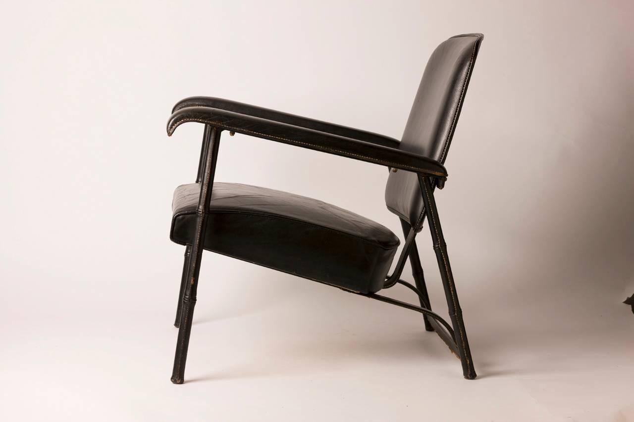 Rare and handsome hand-stitched French leather lounge chair by famed designer Jacques Adnet. Chair features a metal body covered in luxurious hand-stitched leather. Chair is in excellent vintage condition.