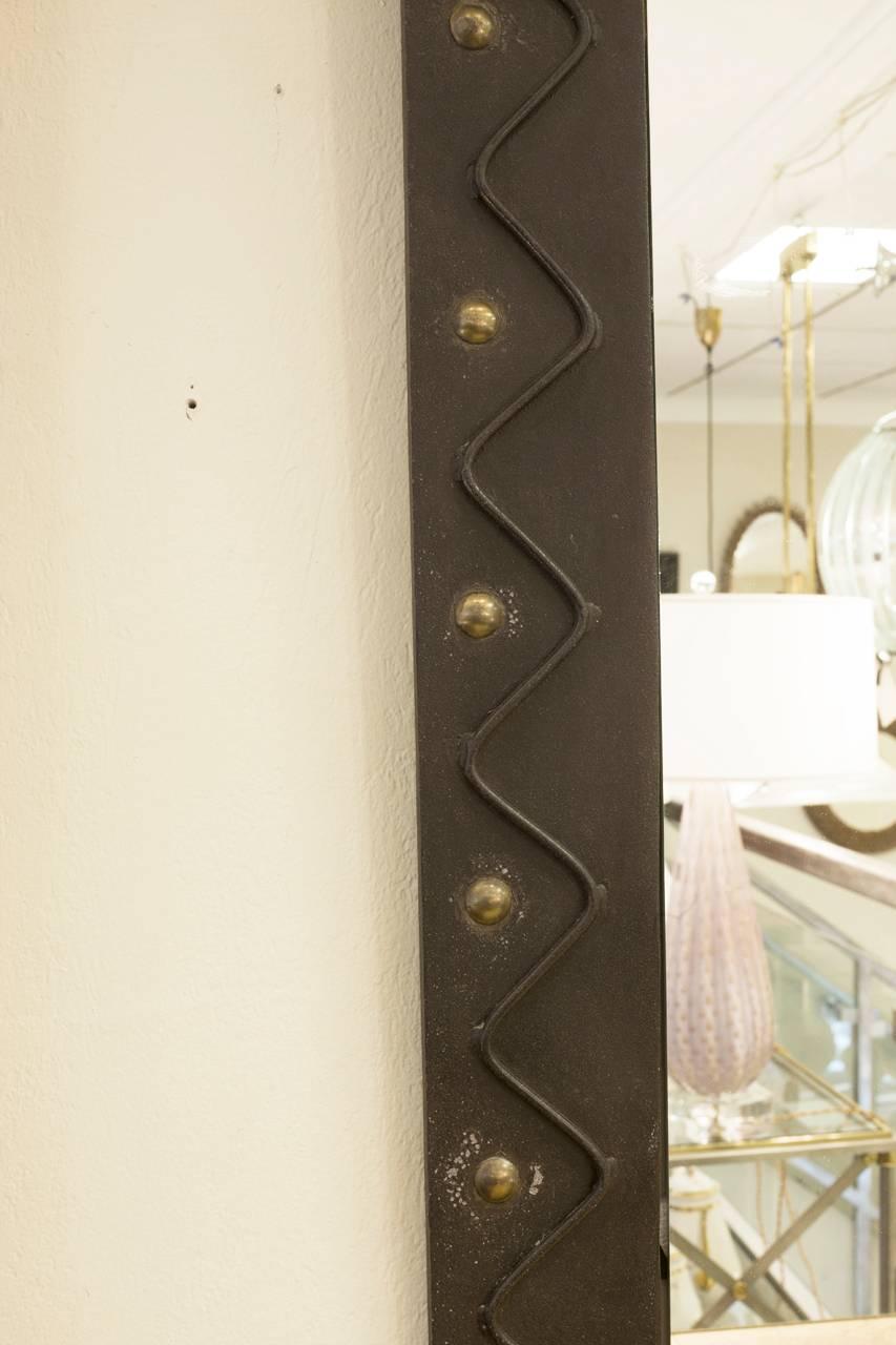 French Brutalist wall mirror in metal with circular gilt ball detail and serpentine accent metal bands.