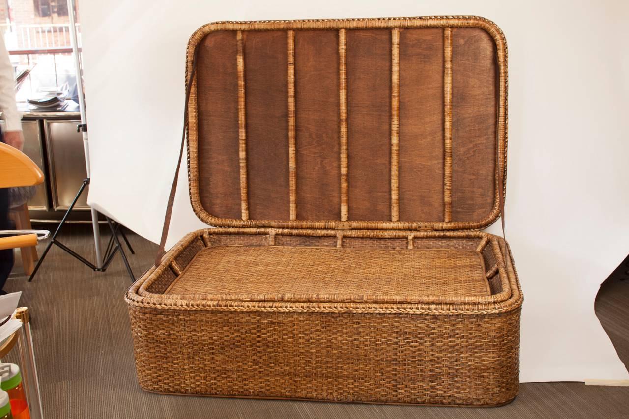 Large-scale French woven wicker trunk or coffee table. Piece features a removable tray which can rest on the tableau or, alternately, be stored within the piece.