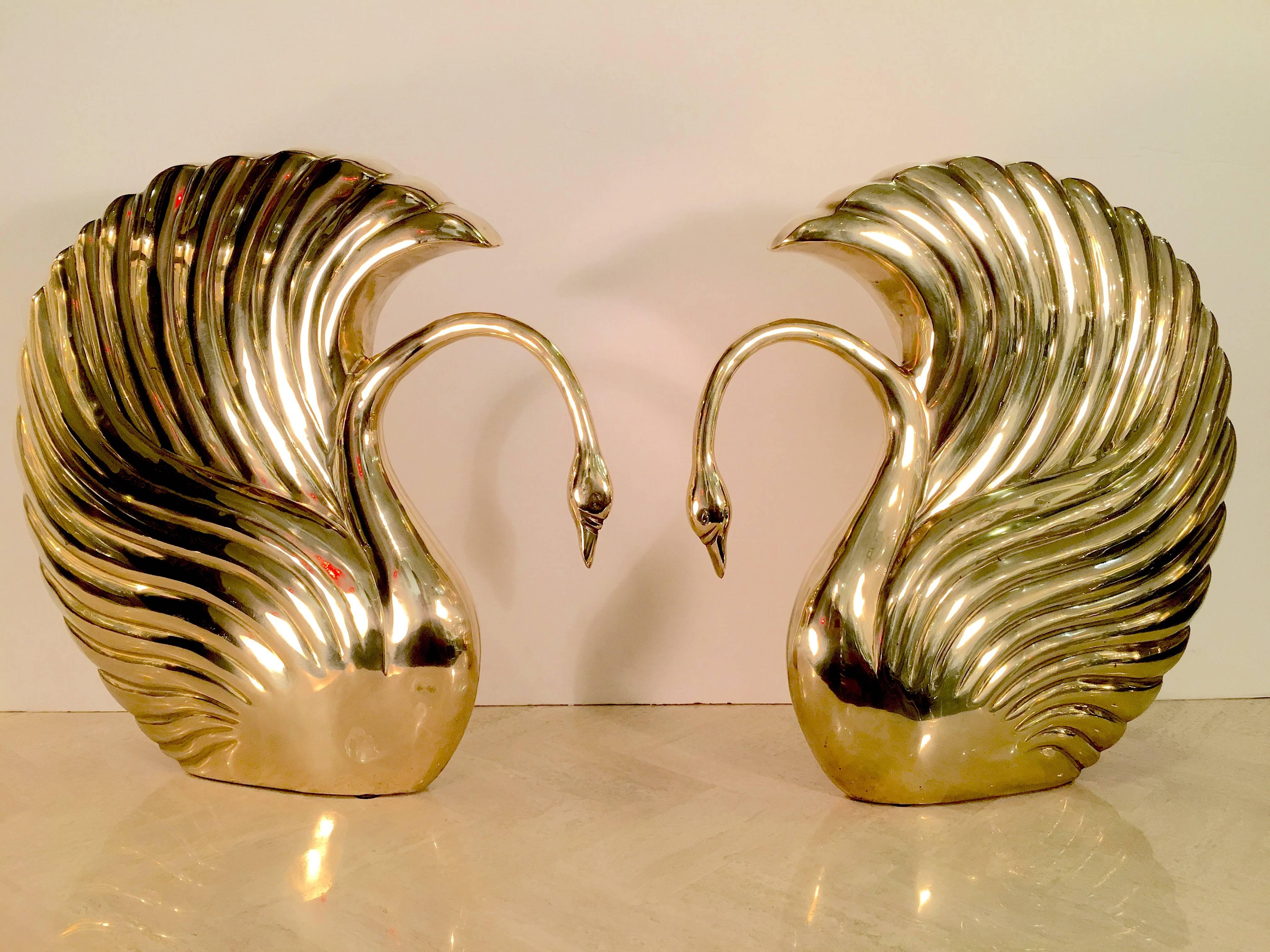 Gorgeous pair of stylized swans from the Art Deco Revival Period of the 1970s and 1980s. The sculptured swans are done in a highly polished brass and make a wonderful statement. These were produced by Dolbi Cashier, the high end interior decor