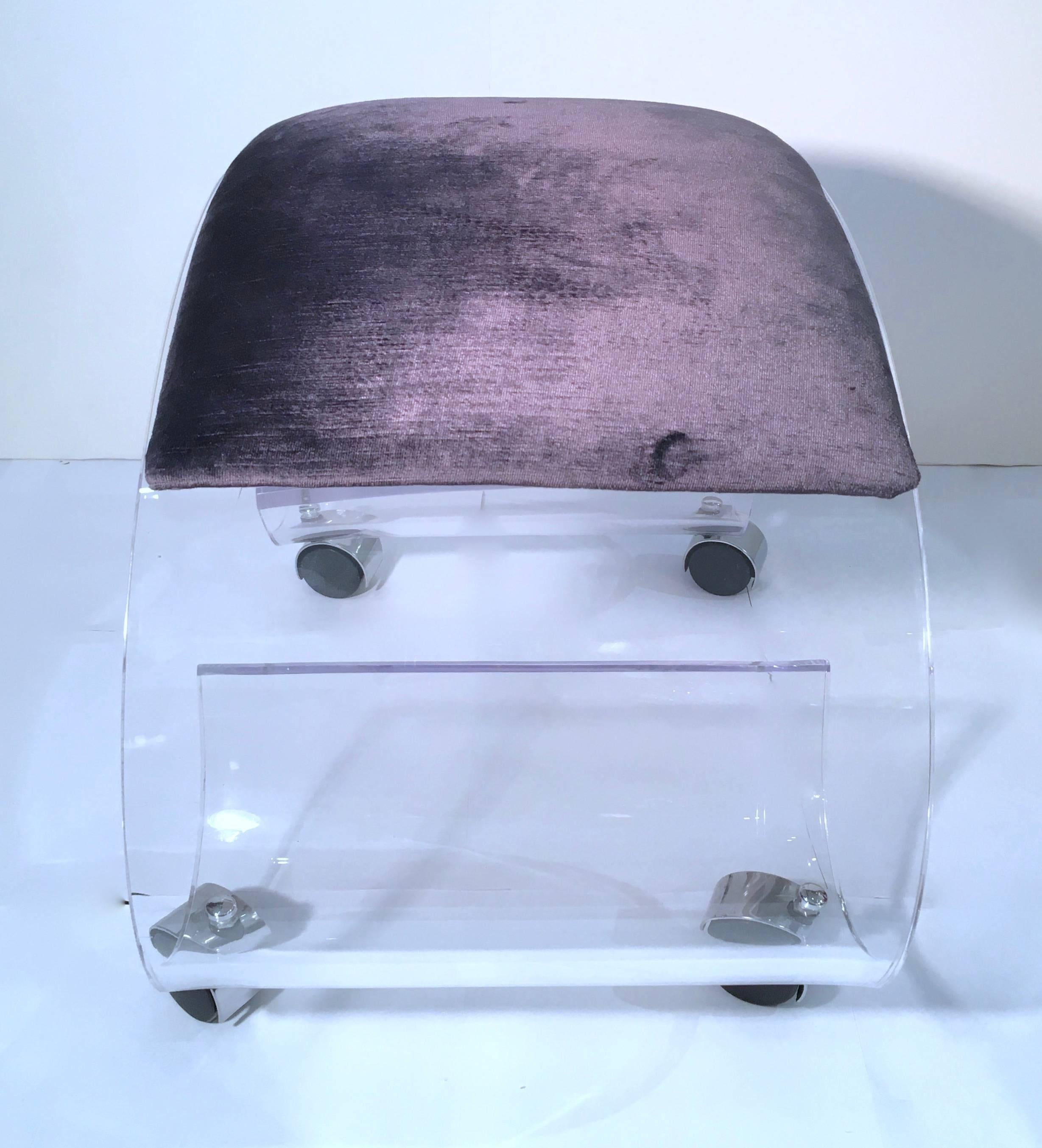 Stylish and charming Lucite scrolled rolling bench or vanity stool upholstered in a purple/gray velvet. Please contact for location. 