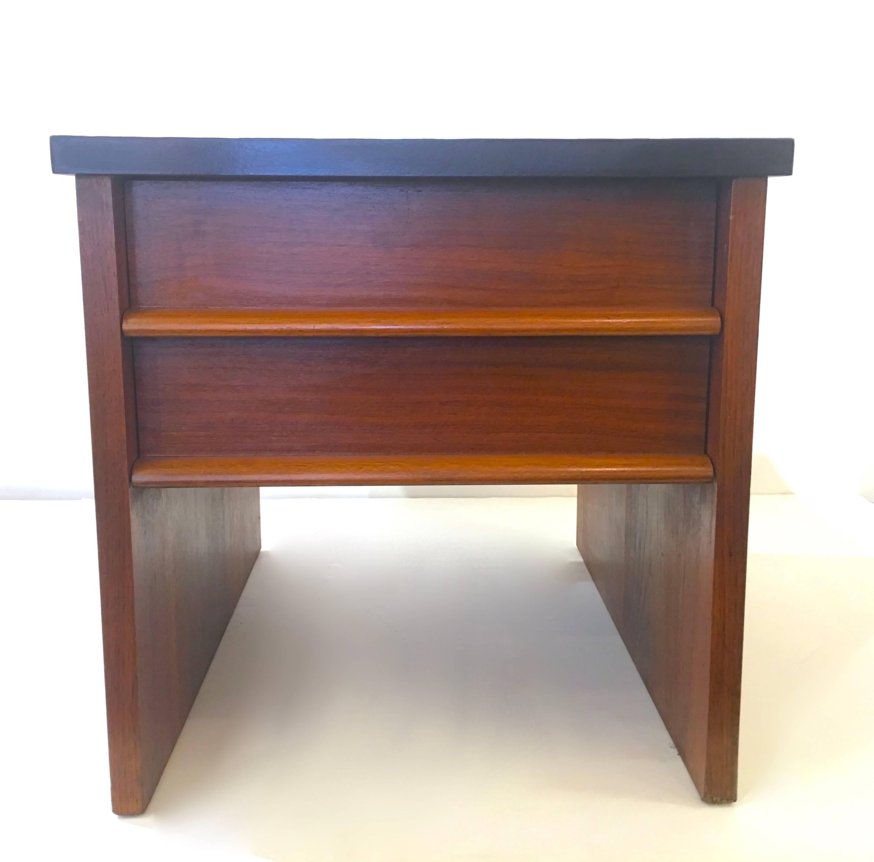 Handsome pair of nightstands in walnut with a faux stone top. The tops of the stands seems to be a textured laminate resembling slate. Please contact for location. 