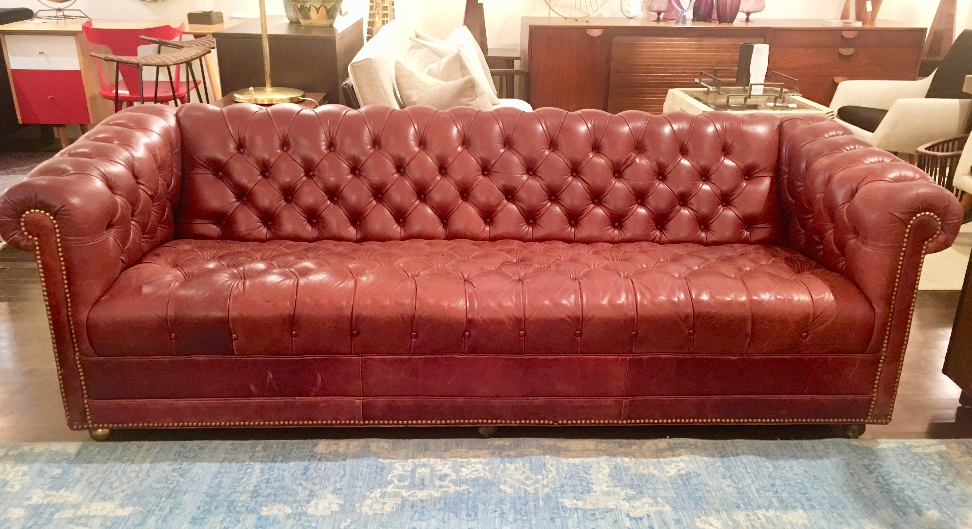Classic Chesterfield sofa in a perfect dark red leather. This is a well made and substantial vintage piece accented with brass nail heads. The leather has some desirable wear and patina. Please contact for location.