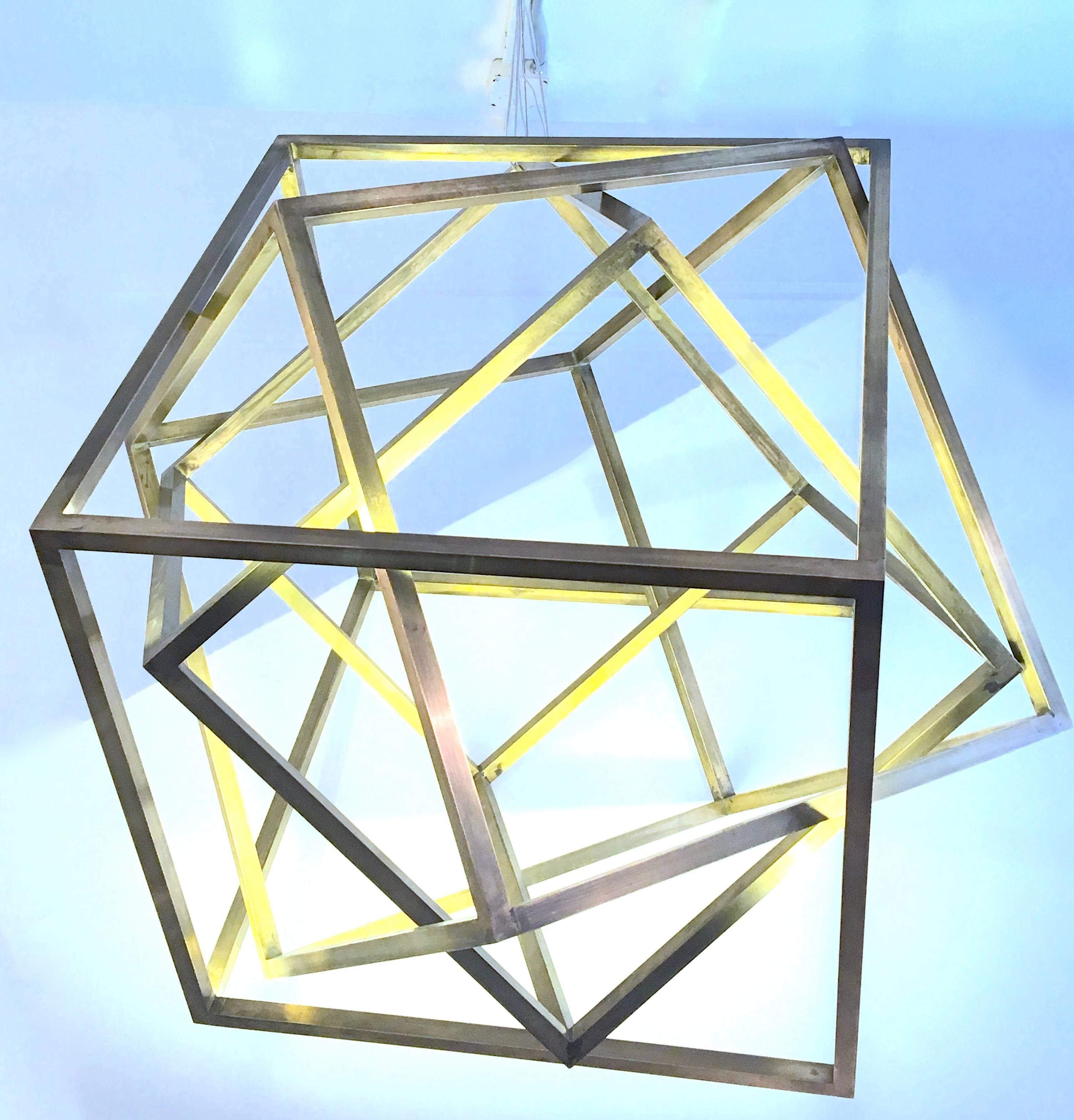 Fantastic architecturally designed chandelier composed of a number of brass finished square cubing elements entirely interlocked. The scale is monumental and the effect is breathtaking. The pendant is finished in satin brass and is softly