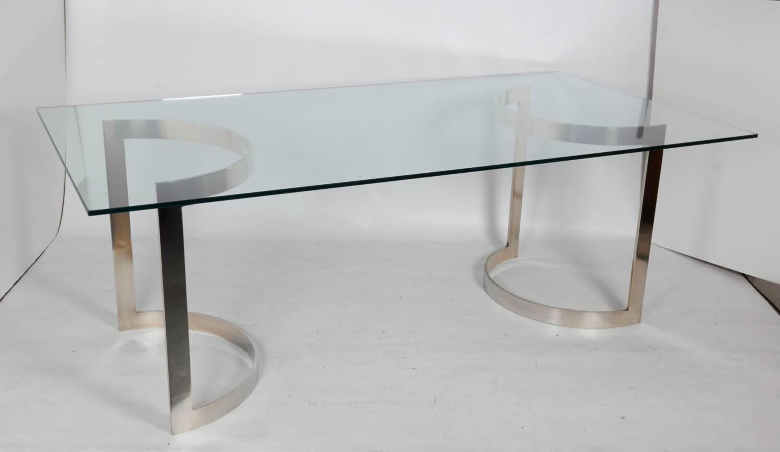 Remarkable glass top dining table with two polished bronze supports. Chic! Please contact for location.