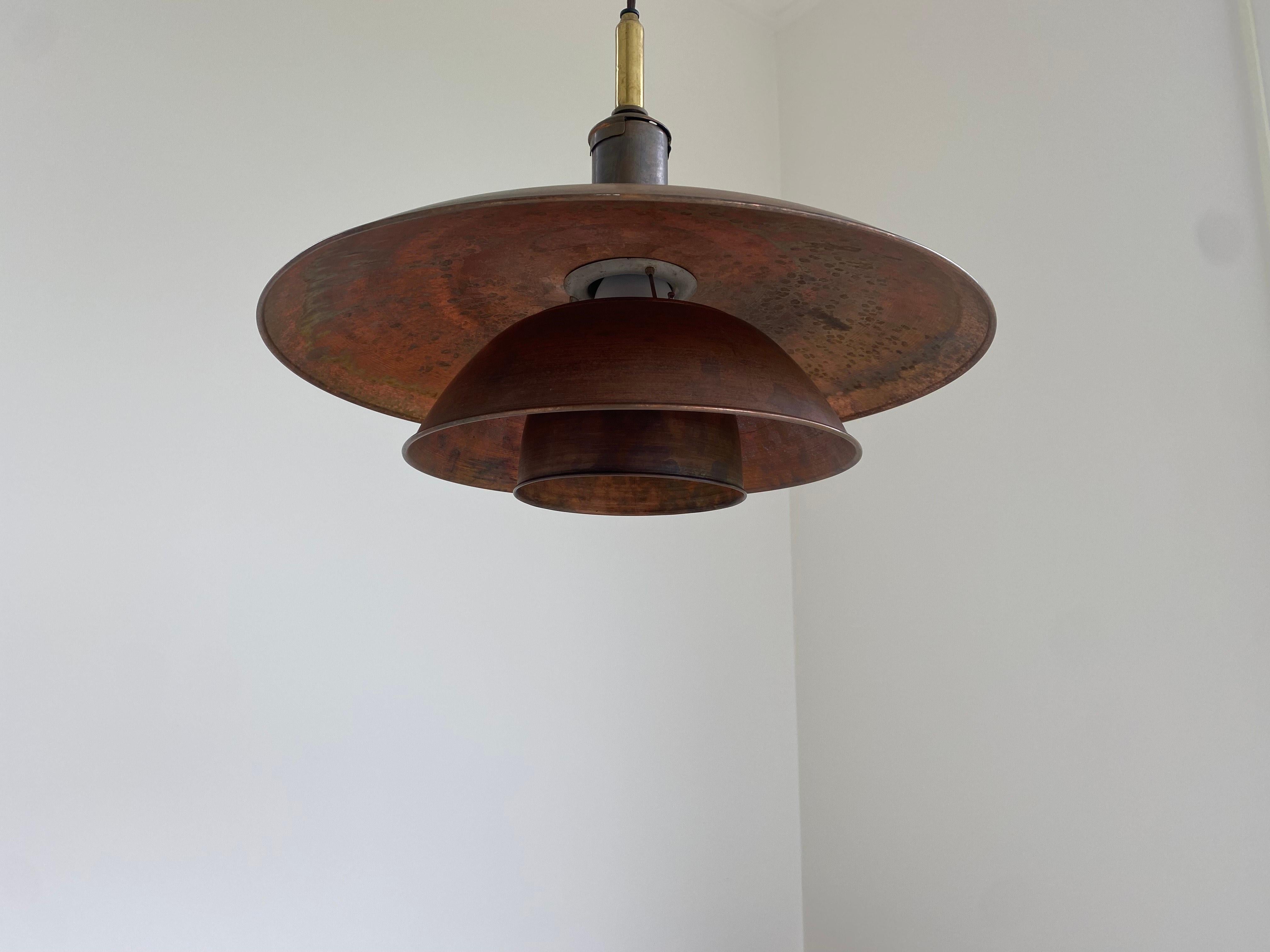 Raro e grande ciondolo PH in rame e ottone, disegnato da Poul Henningsen e prodotto da Louis Poulsen.
Modello iniziale. Timbro 'Brevettato'

Ciondolo con tre paralumi che offre una splendida distribuzione della luce.

In buone condizioni d'epoca con