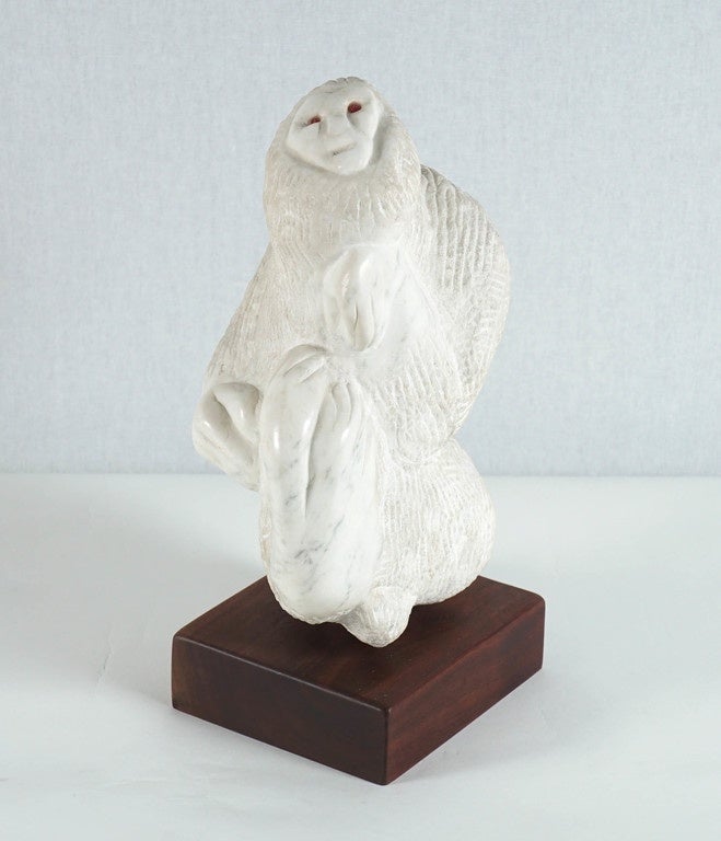 Here is a marble sculpture of a monkey in a modernist style on a walnut base.