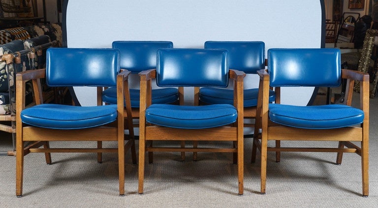 Here is a set of ten armchairs with blue upholstered backs and seats. The seat has a tweed fabric and the sides and backs are in vinyl. The chairs are sturdy with slight vintage wear. These chairs are available as pairs for $950. The set of ten is