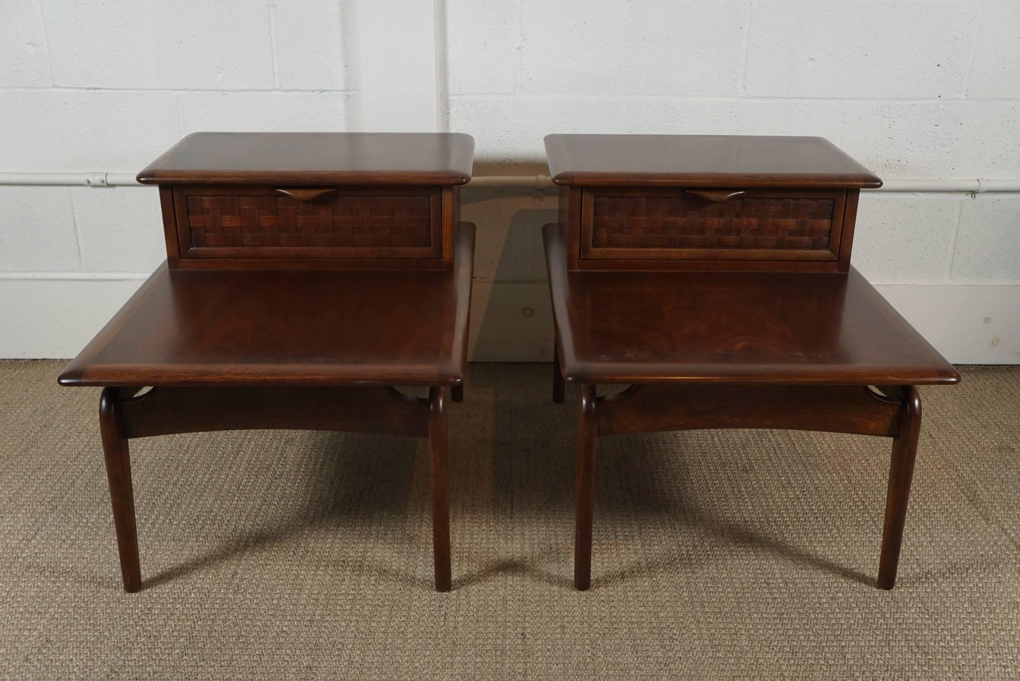 Here is a beautiful pair of walnut stepped tables with a basket weave drawer front. The tables have accent brass spheres that add a nice detail. Newly refurbished, the tables have a a beautiful satin finish and are in excellent condition. The height