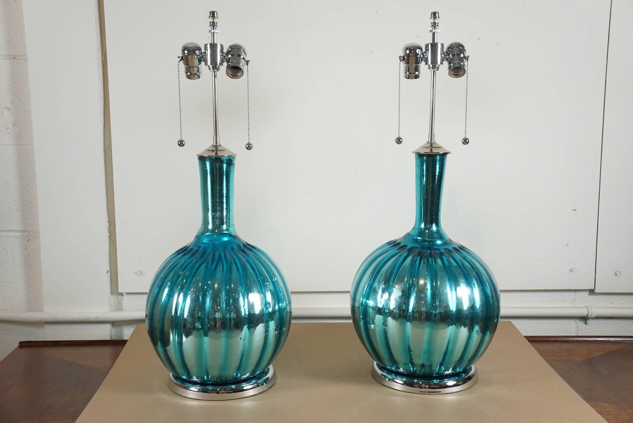 Here is a stunning pair of mercury lamps in an aqua blue color.
The lamps are in excellent condition with new chrome hardware and new wiring with double stem sockets. The top of the stem is 27 inches high and the base measures 18 inches high.