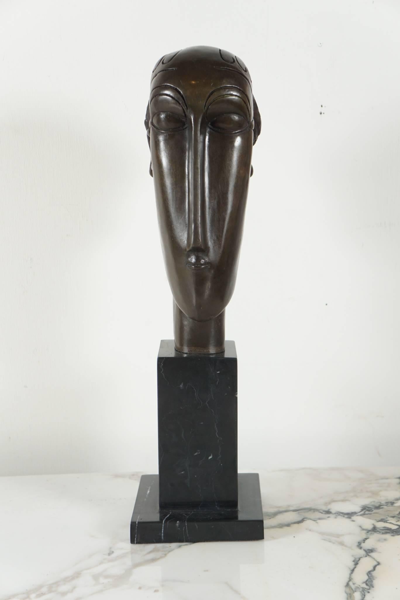 Here is a great Modigliani style bust in bronze of the artist's Primitive series. The elongated and stylized head is elegant and modern and is attached to a black marble base.