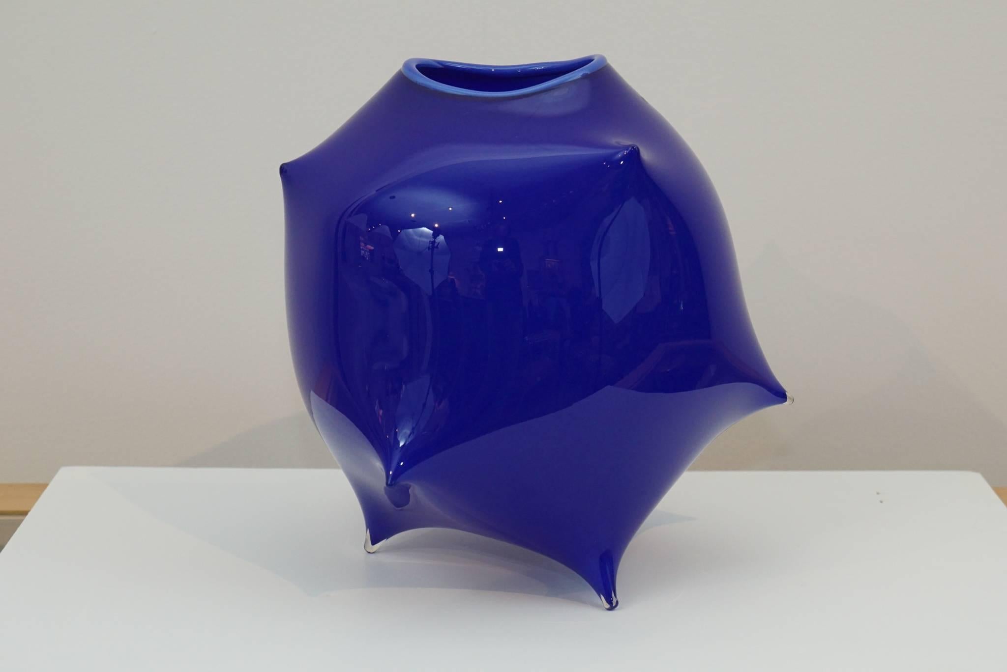 Here is an amazing art glass vessel in cobalt blue. The biomorphic design is modern and has very pointed pinched detail surround. Signed and dated by the artist in 2001.
The name is not legible and appears to be initials.