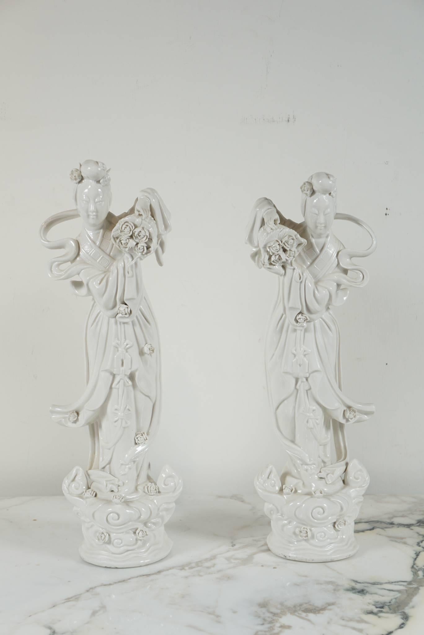 Here is a lovely pair of Blanc de Chine figurines with flowing lines and intricately carved flower details.